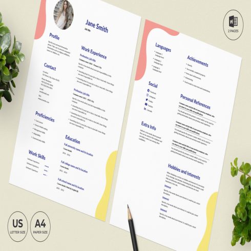 Pair of resumes sitting on top of a table next to a plant.