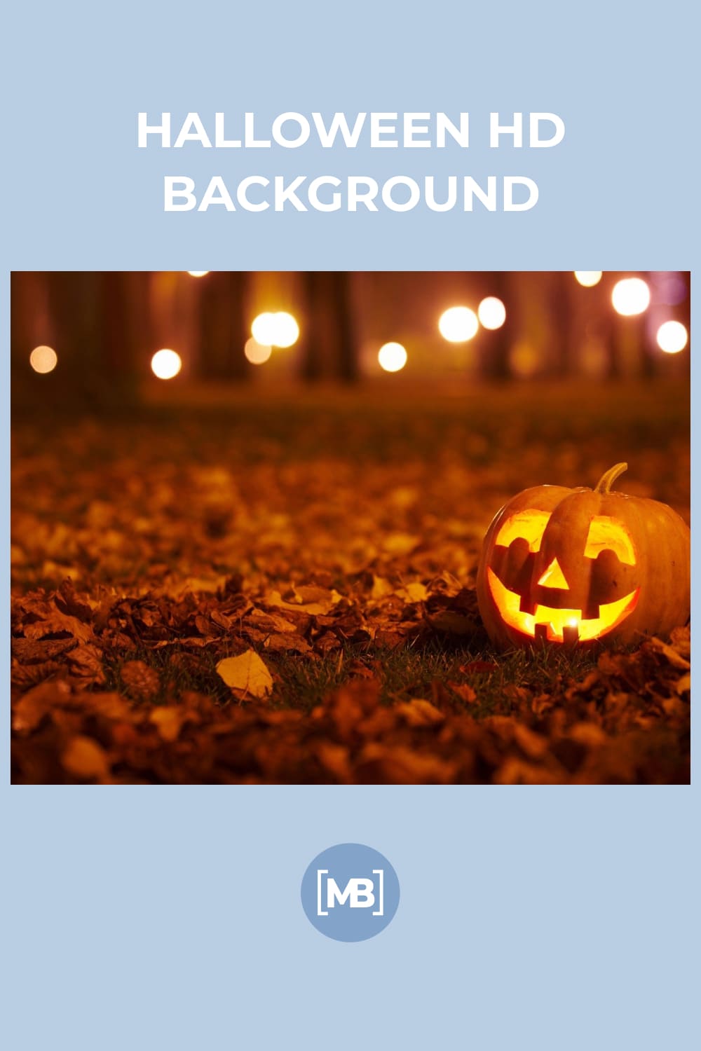 Photo of a pumpkin with a candle inside on the grass among the fallen leaves.