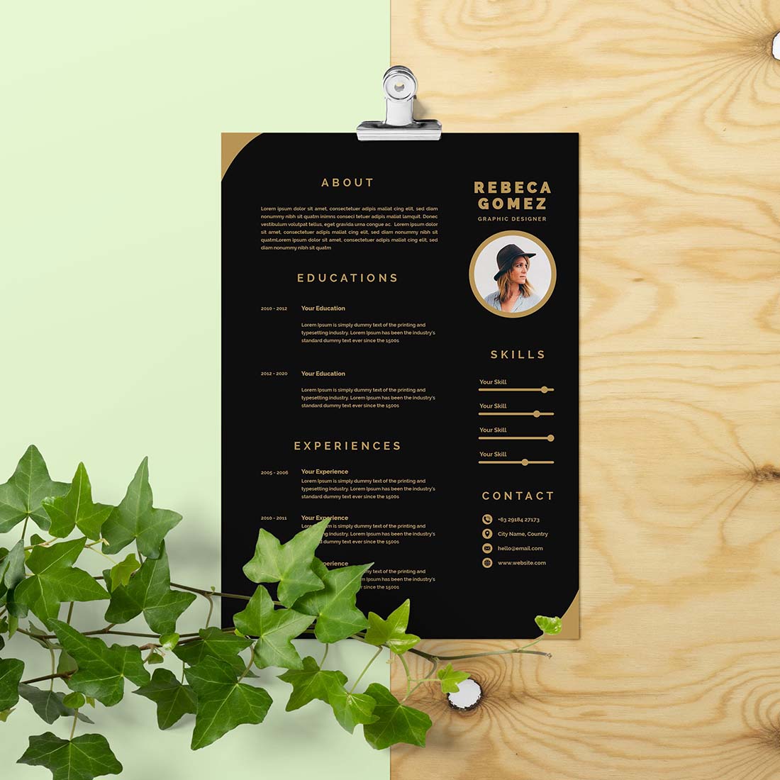 Black and white resume on a clipboard next to a plant.