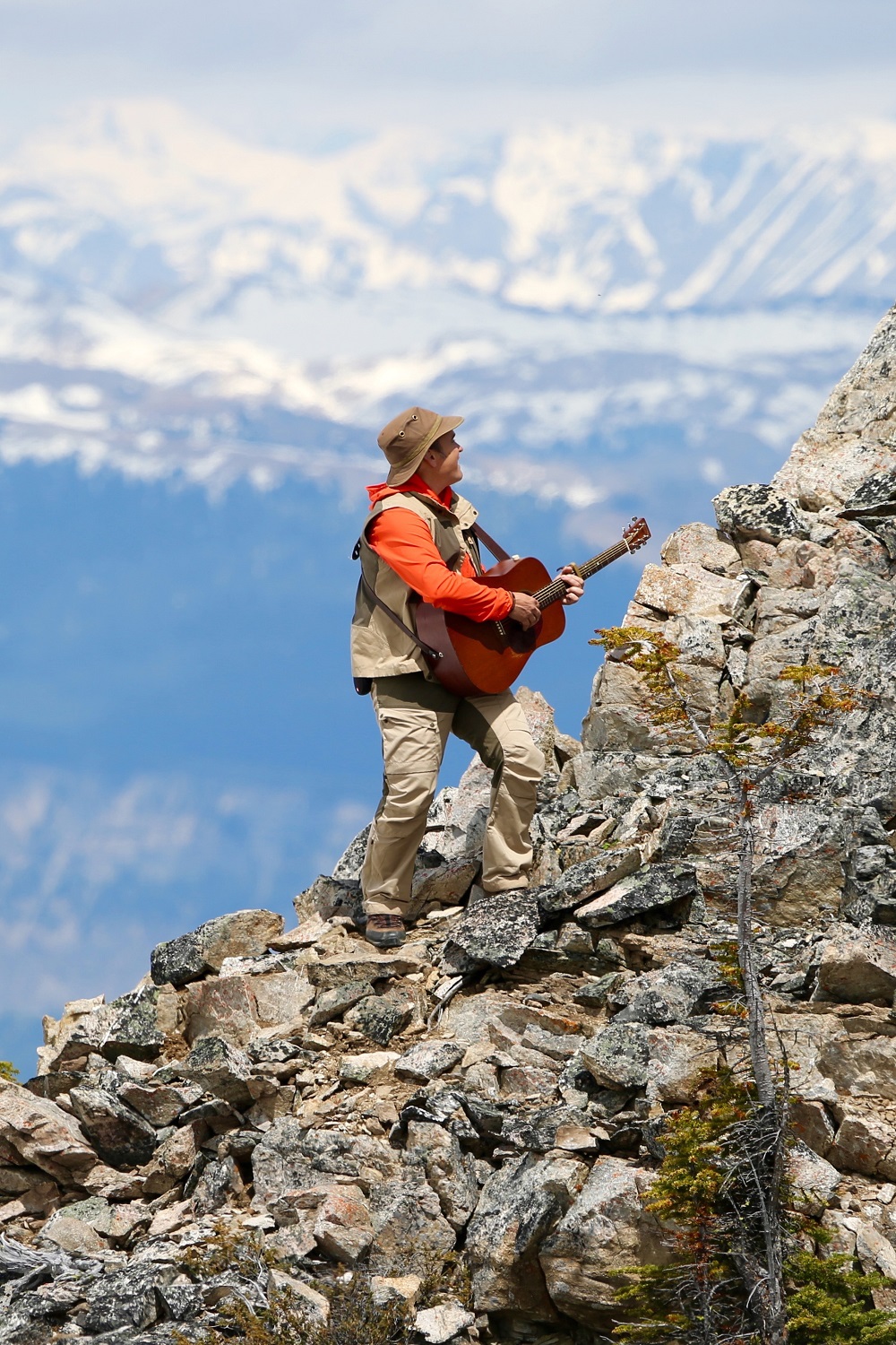 man climbing rocky mountain while playing guitar pinterest
