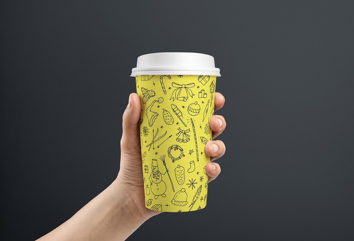 Yellow paper cup with the dark Christmas ornament.