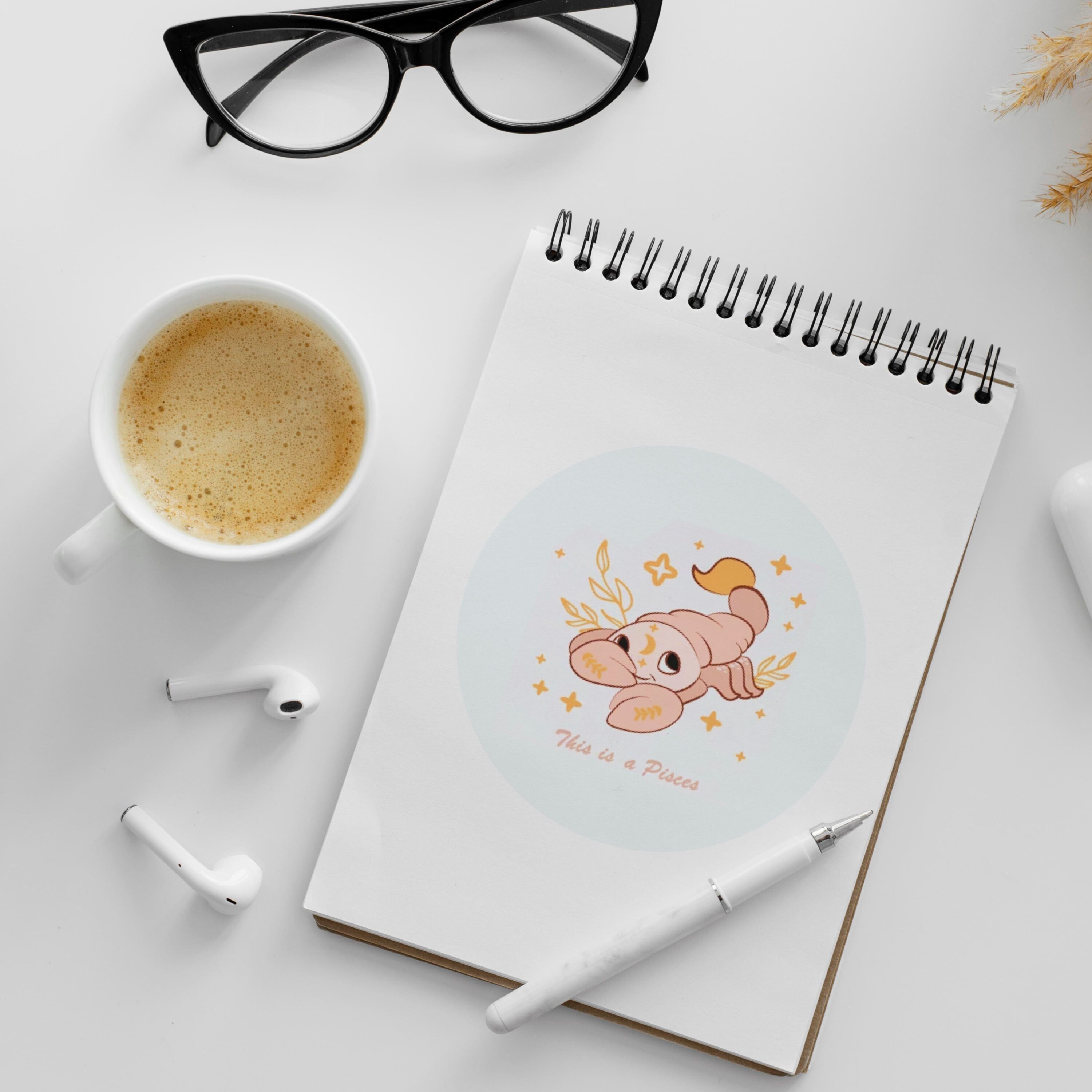 Notepad with a picture of a baby on it next to a cup of.