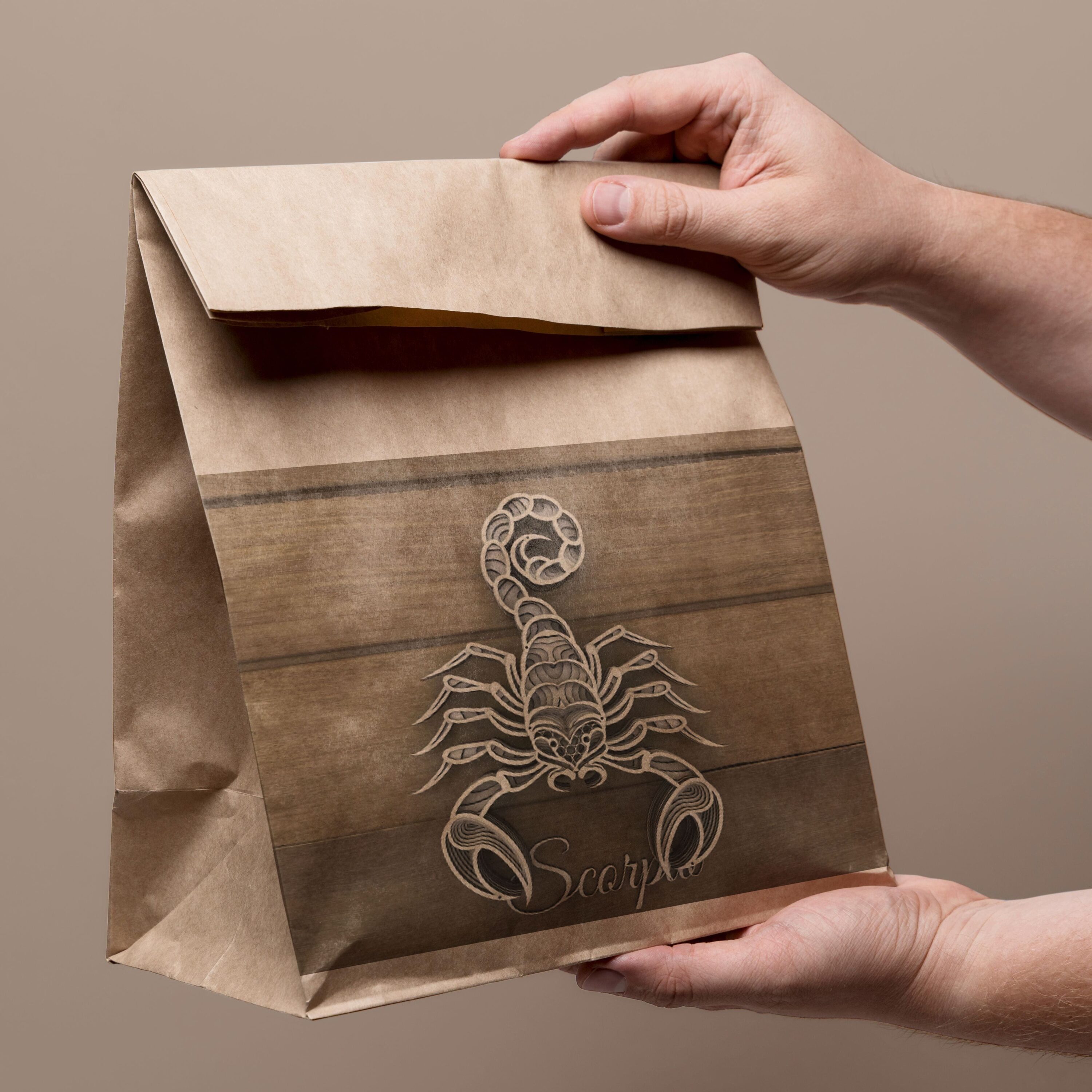 Person holding a brown paper bag with a scorpion on it.