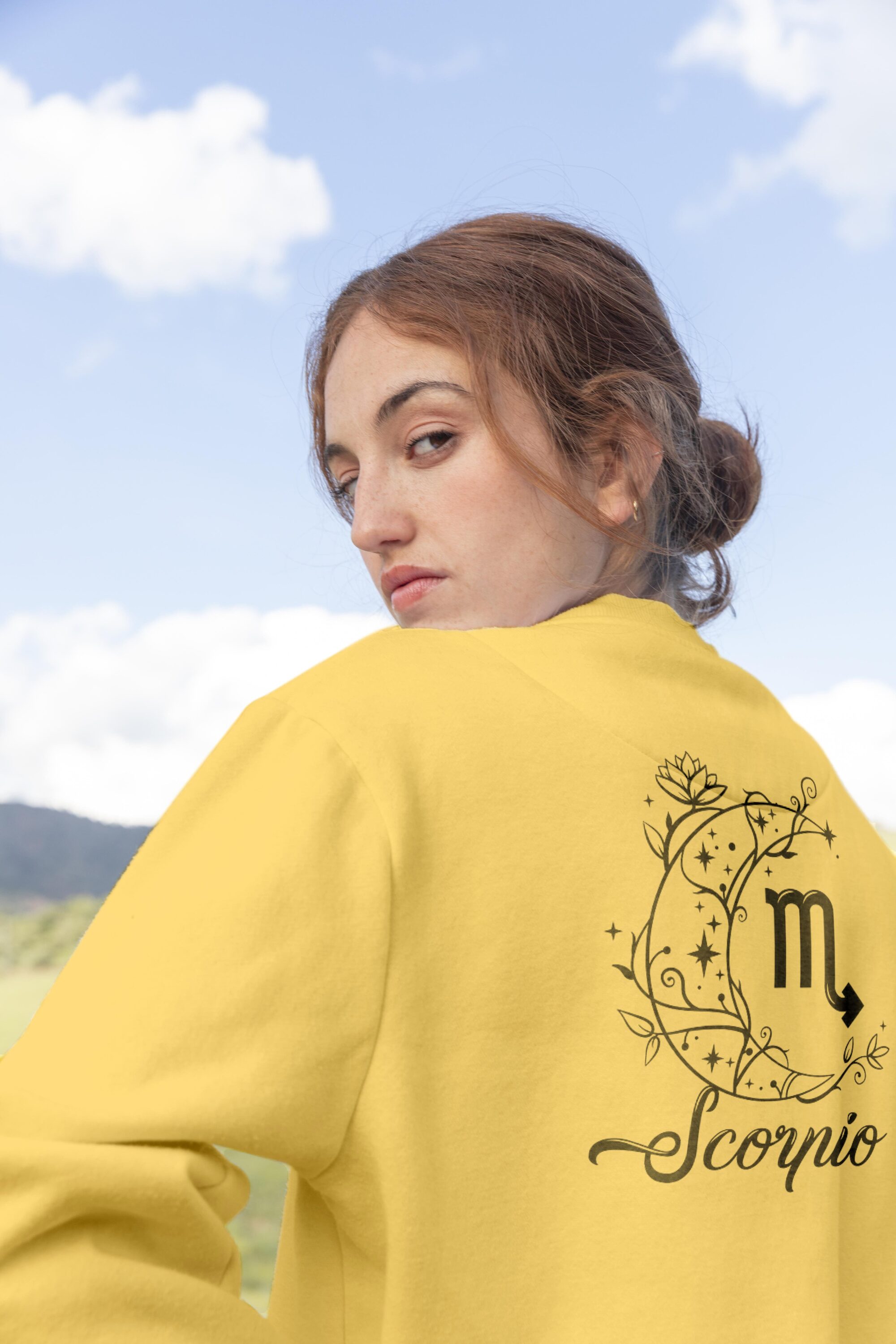 Woman wearing a yellow zodiac zodiac sweatshirt.