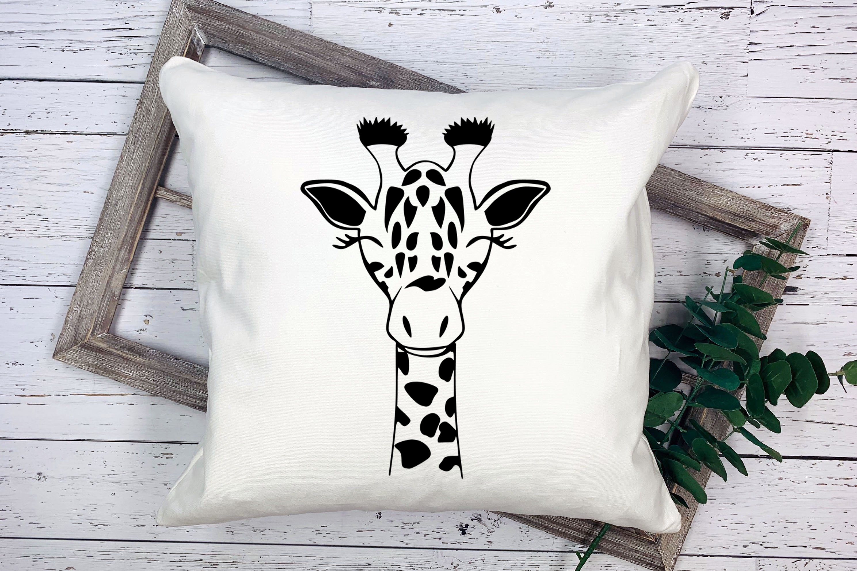 Pillow with a giraffe's head on it.