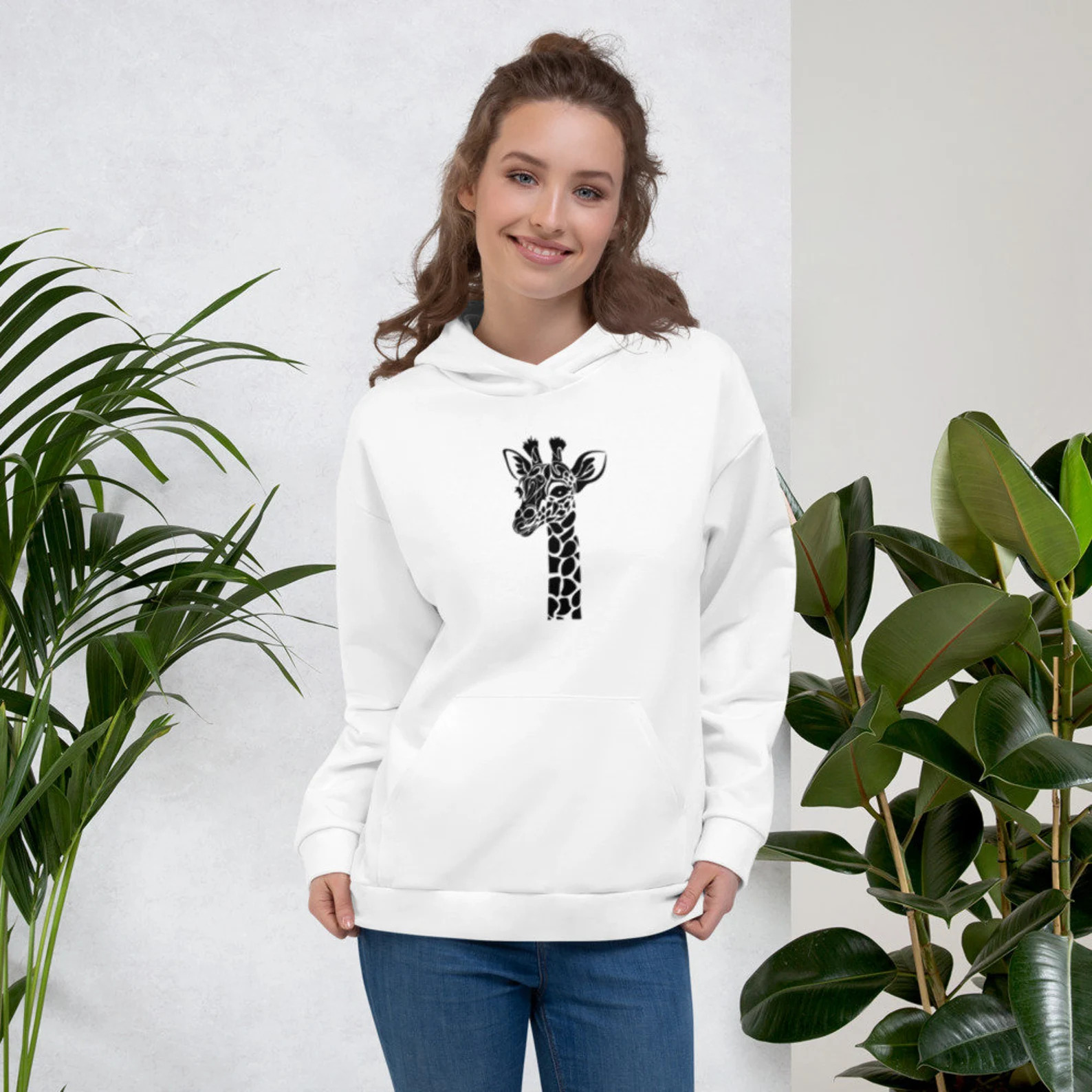 Woman wearing a white hoodie with a giraffe on it.