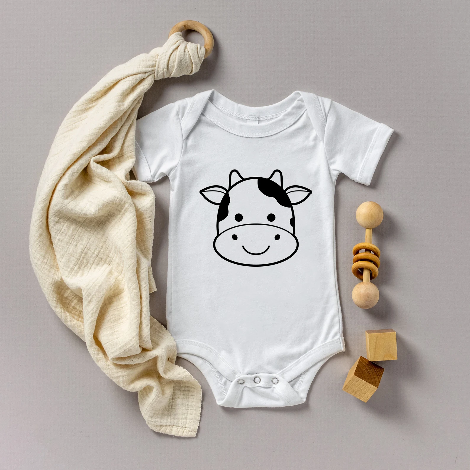 Baby bodysuit with a cow face on it.