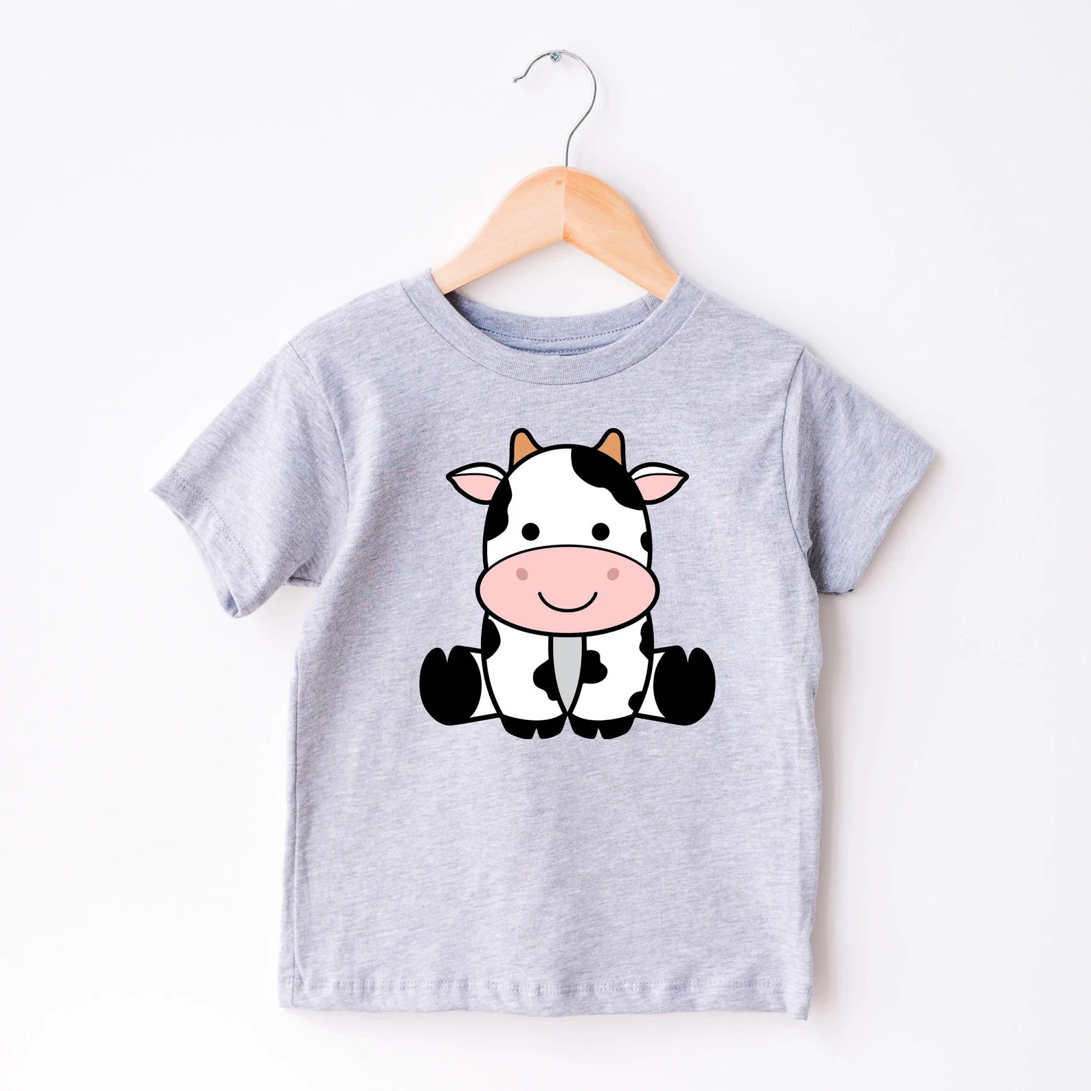 Baby t - shirt with a cartoon cow on it.