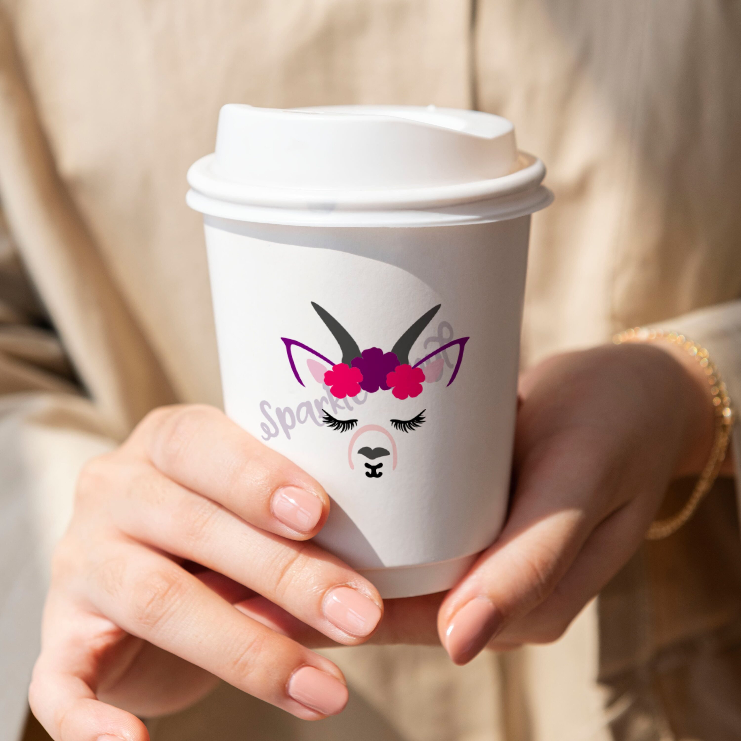 Woman holding a cup with a unicorn face on it.