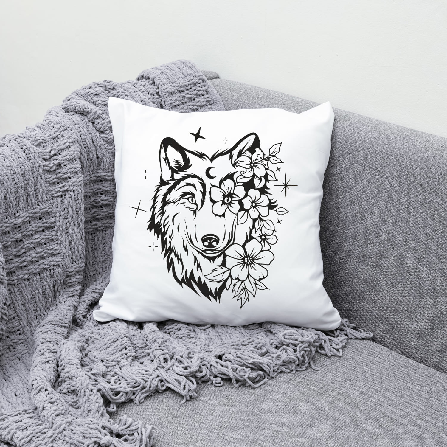 White pillow with a wolf and flowers on it.