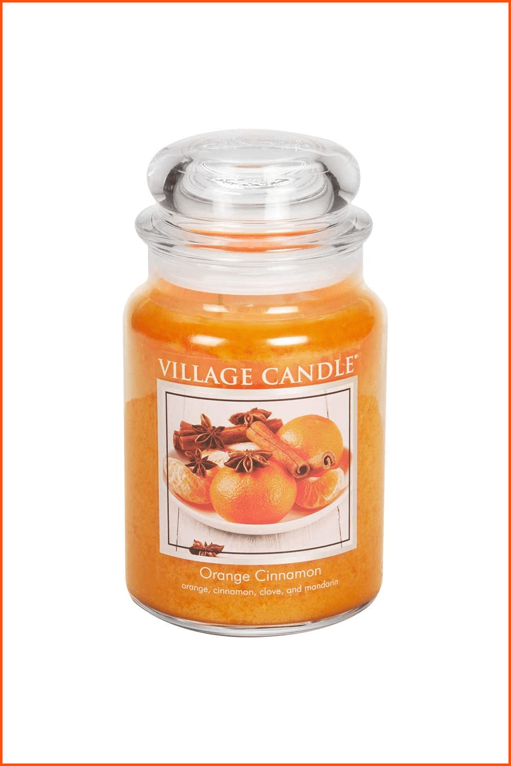 Orange wax candle with oranges and cinnamon sticks.