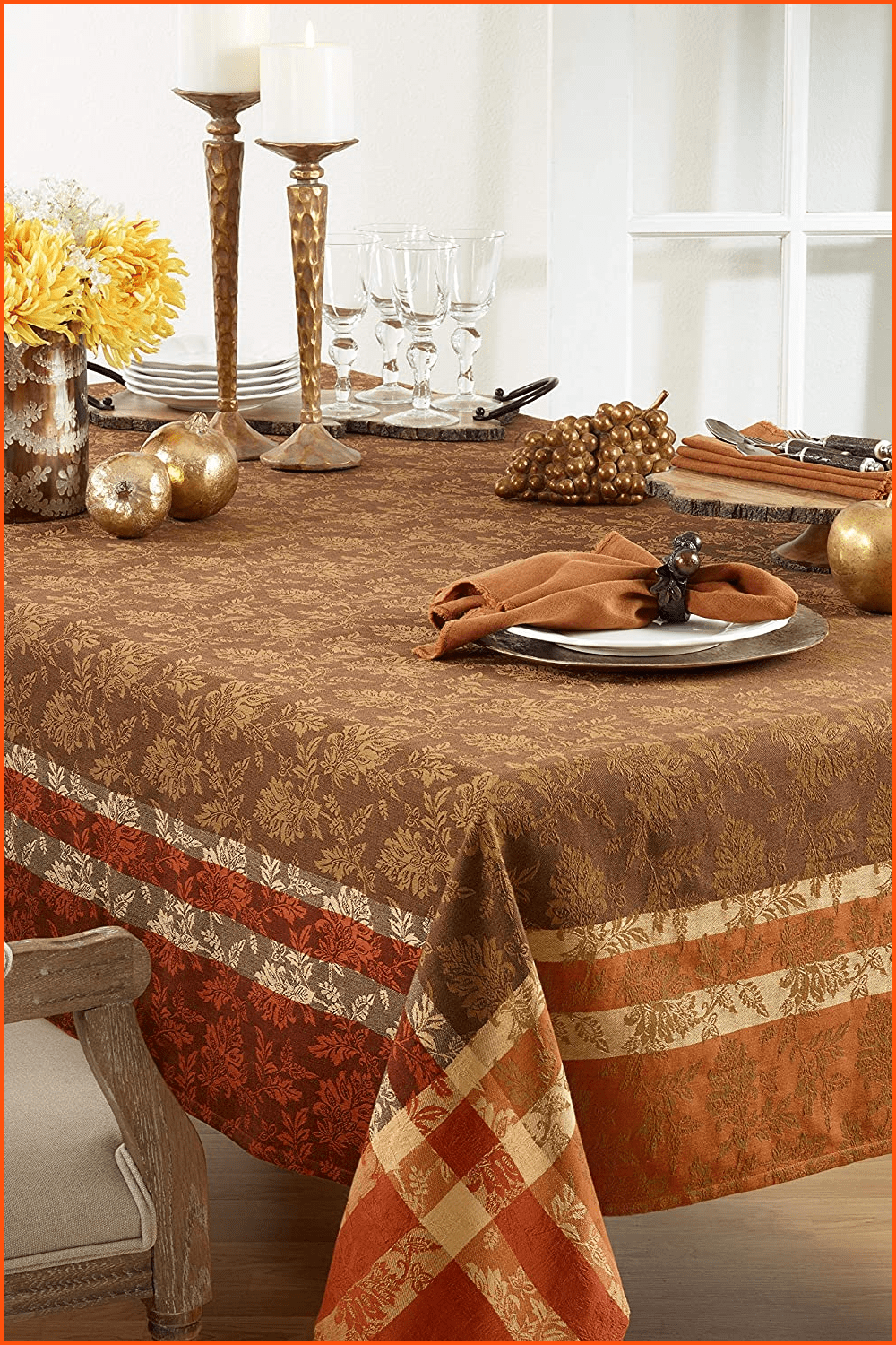 Brown tablecloth on a table with gold decor and white plates.