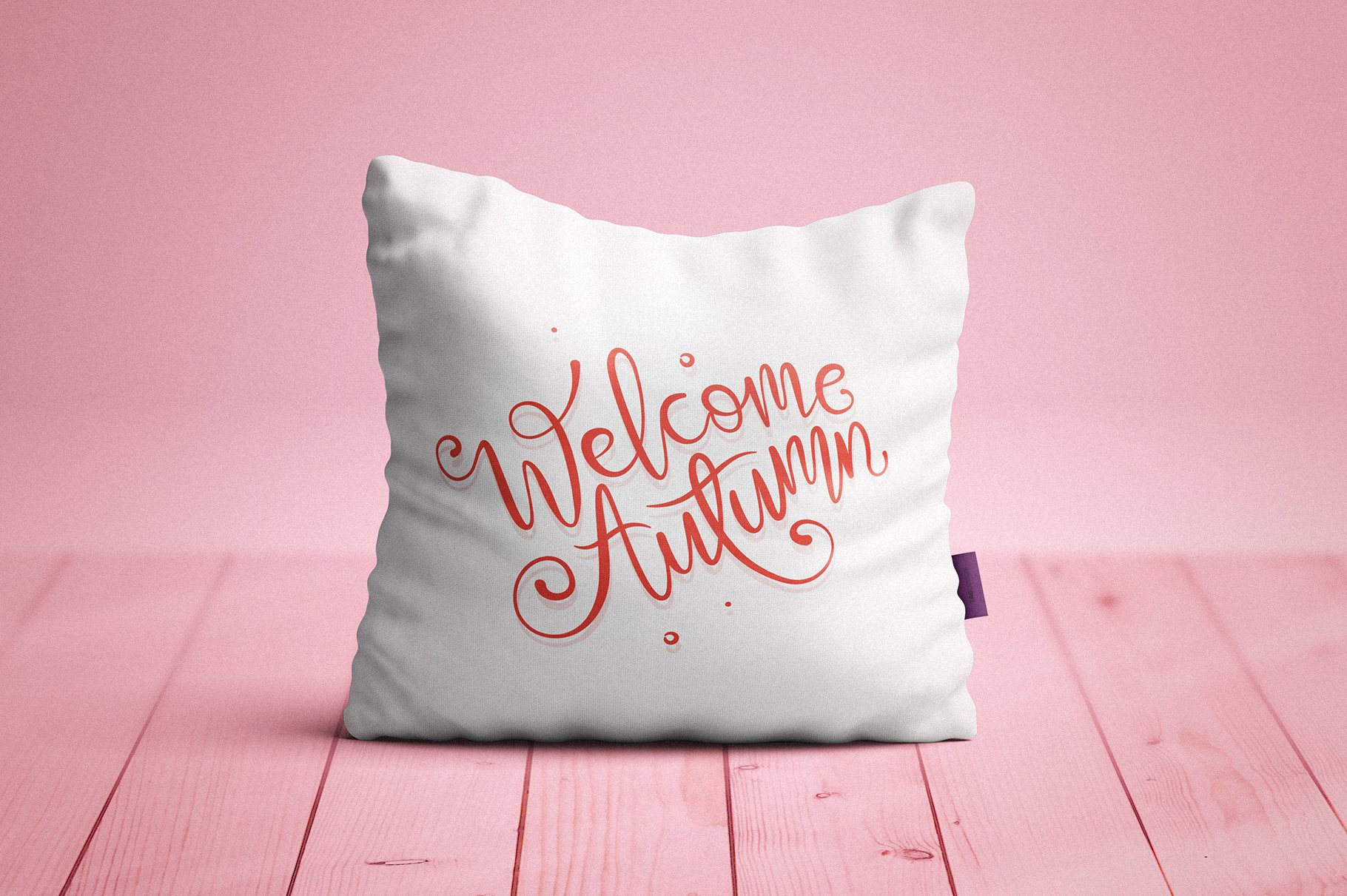 White pillow with a pink phrase.