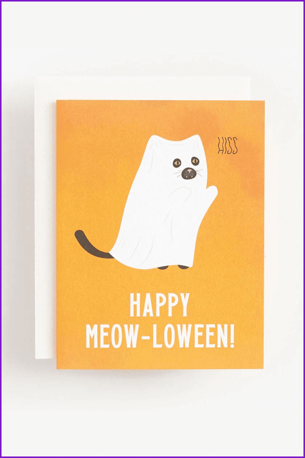 Kitten in a white ghost cape on a yellow background.