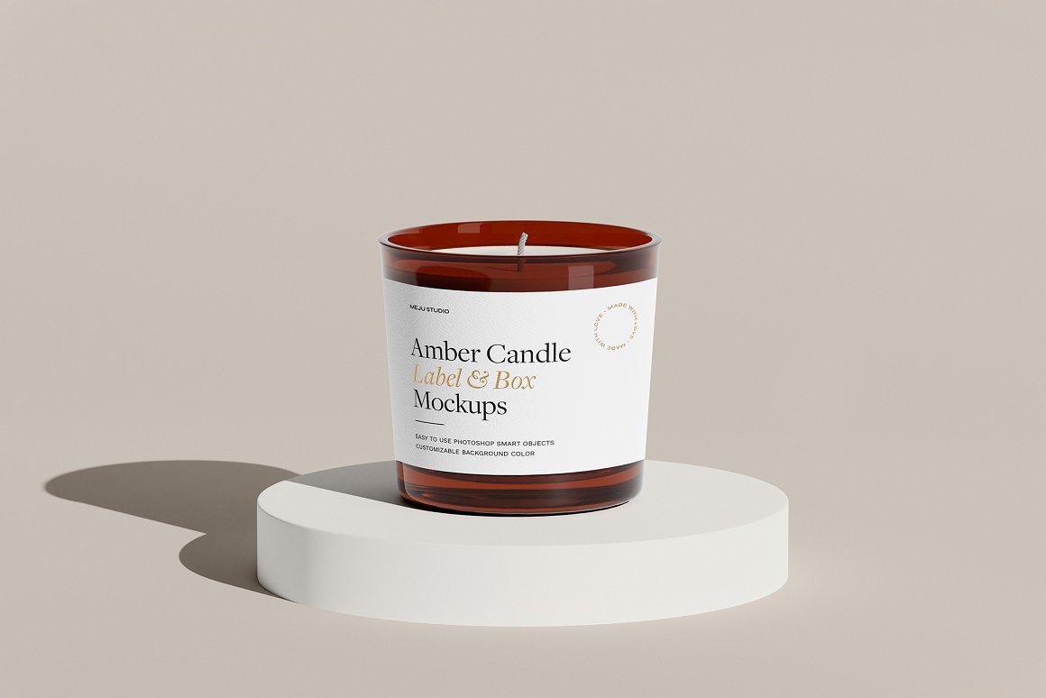 Amber Glass Candle with white label and the lettering "Amber Candle Label & Box Mockups" on a white stand.