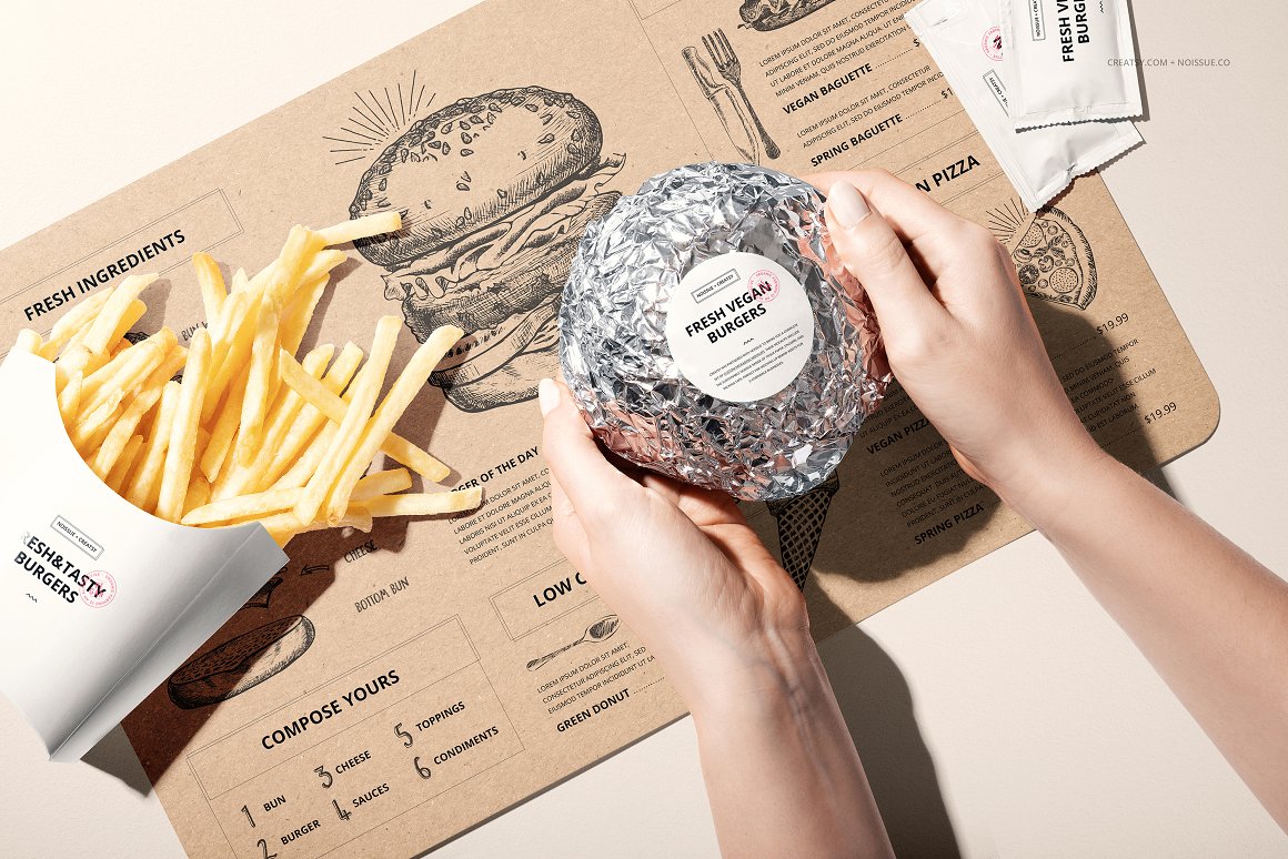 Fresh vegan burger packaged in foil with a white label and french fries in a white carton.