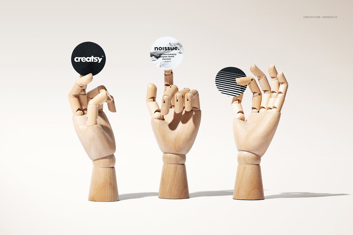 3 wooden hand mockups holding stickers in black and white.