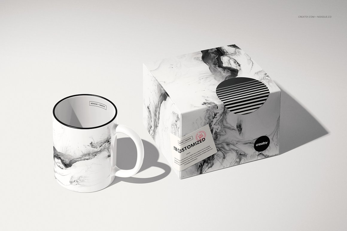White cup with black edging and print in black and white smoke and a box with the same print.