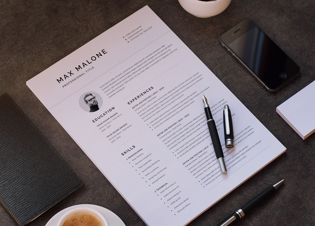 Cup of coffee next to a paper with a resume on it.