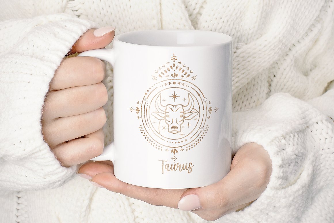 Hands hold a white cup with the golden sign of the zodiac - Taurus.