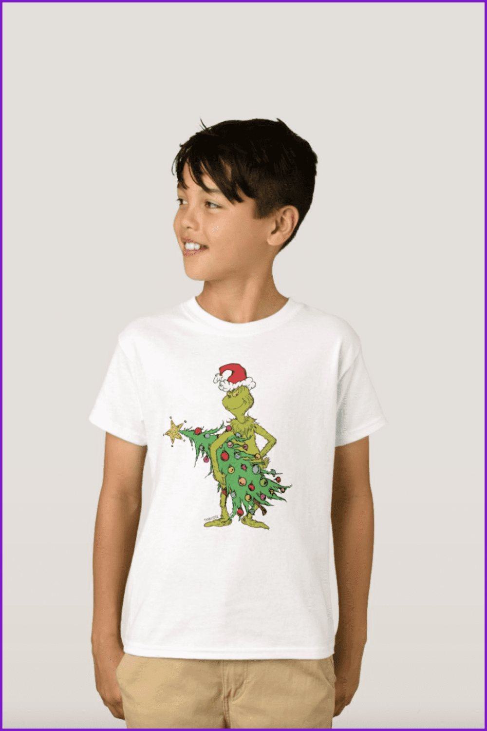 Boy in the t-shirt with the Grinch holding the Christmas tree.
