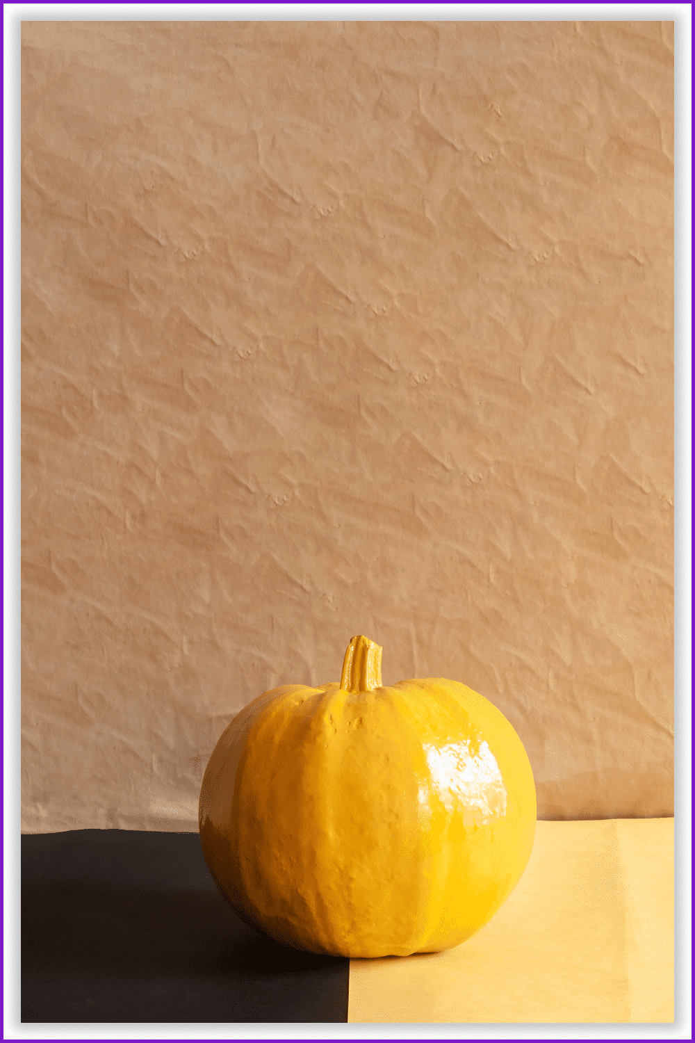 Photo of a large yellow pumpkin on a brown background.