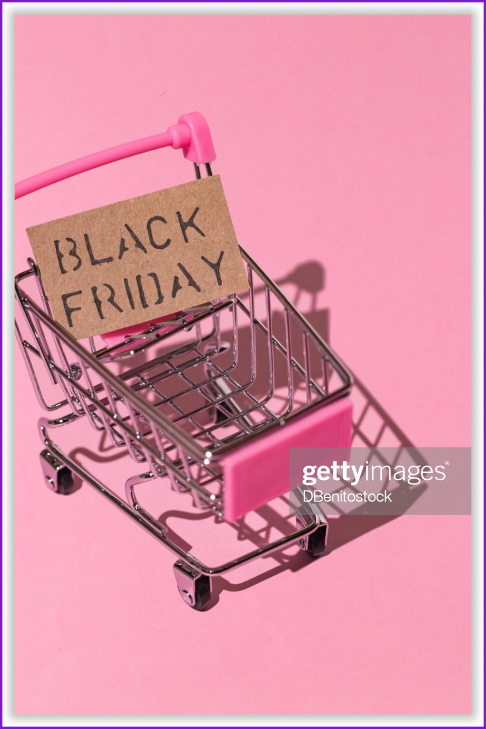 Shopping cart with the sign “Black Friday” on the pink background.