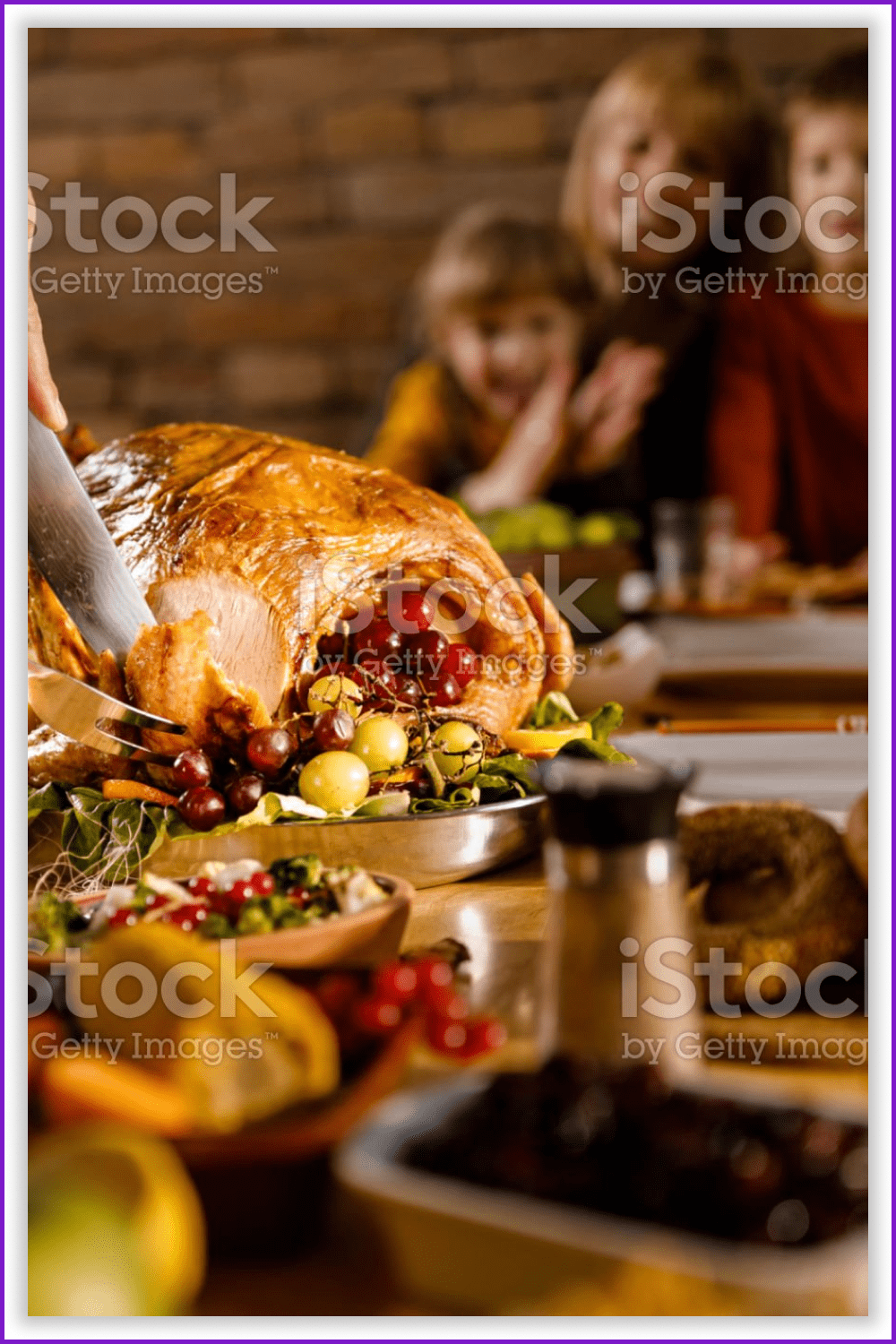 Some one hands cutting a turkey during a Thanksgiving dinner.