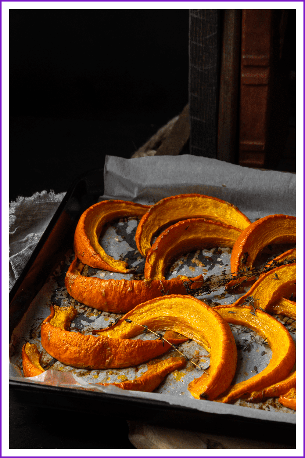 A high-quality photo of baked pieces of pumpkin on a baking sheet.