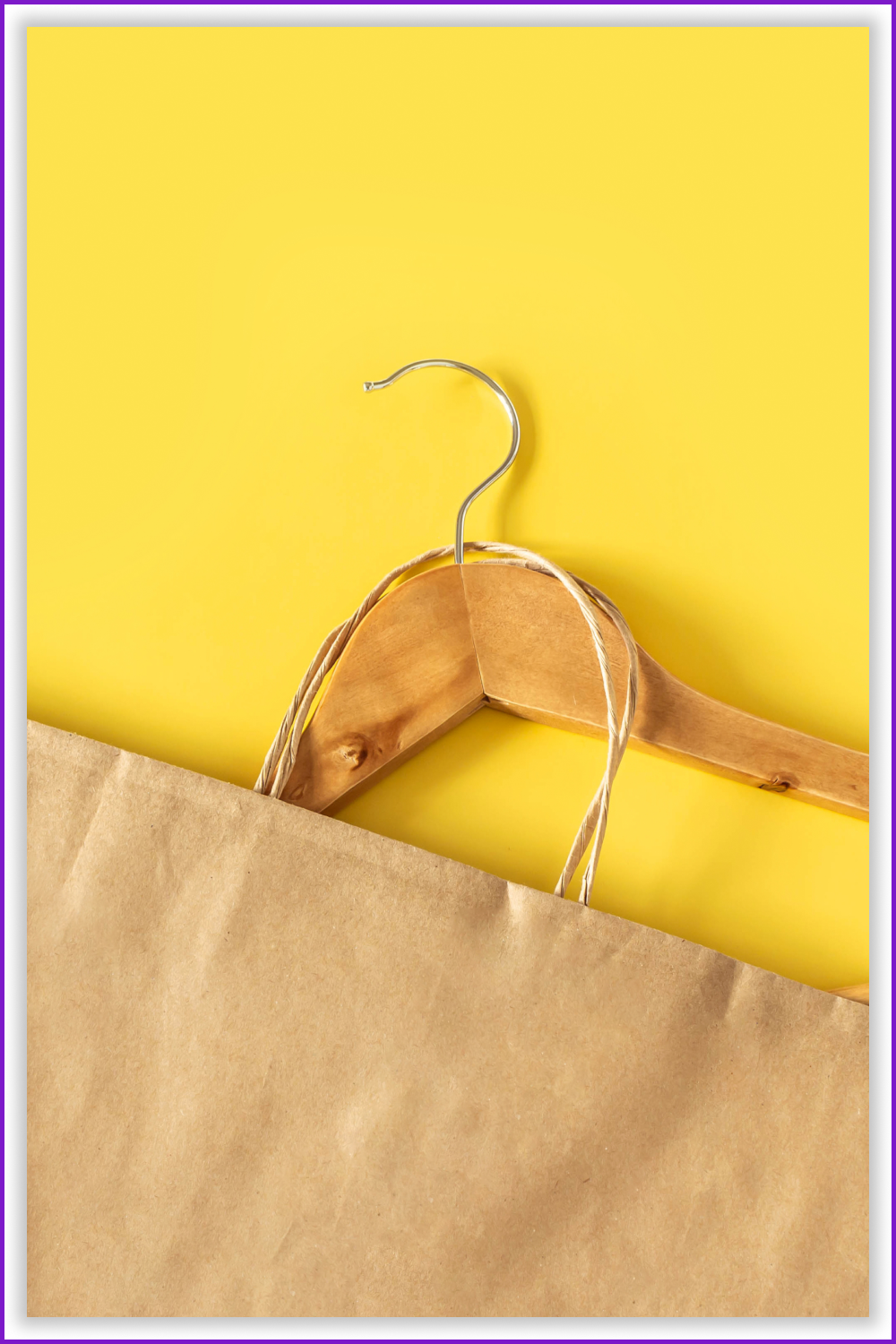 Hanger with a brown paper bag on the yellow background.