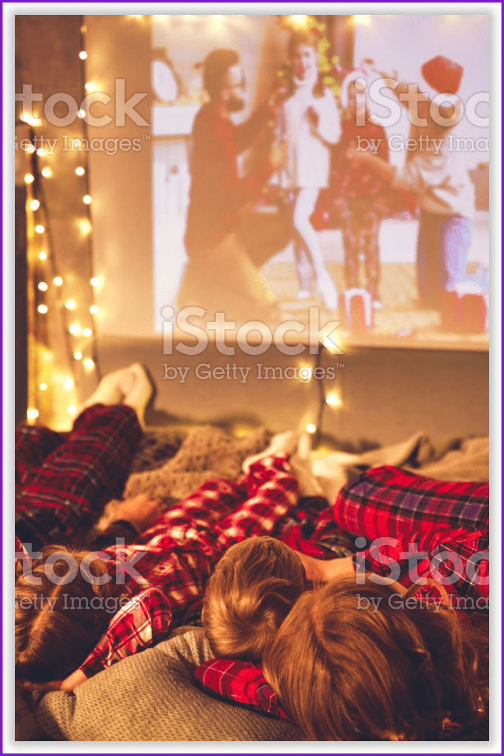 Photo of a family in pajamas watching a Christmas movie.