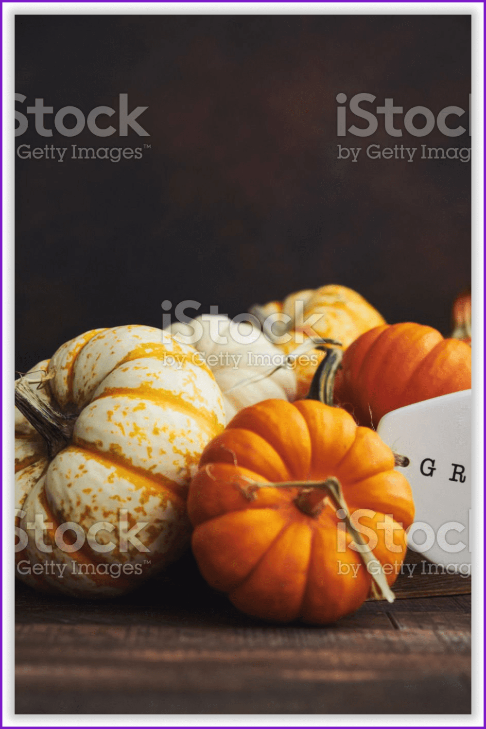 An image of miniature pumpkins in a wooden crate with the label stating “GRATEFUL”.