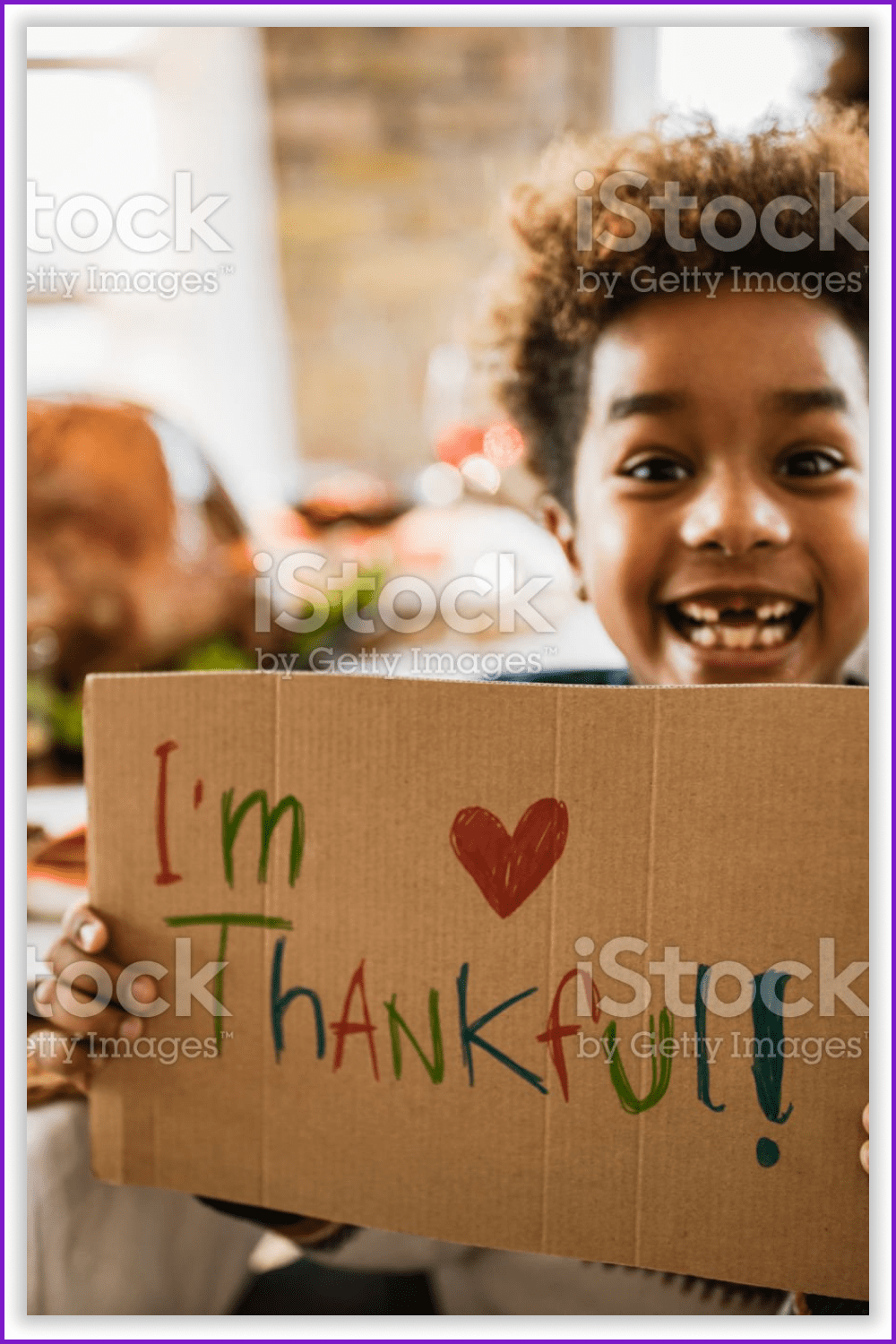 A girl holding the 'I'm thankful' sign at the Thanksgiving dinner.