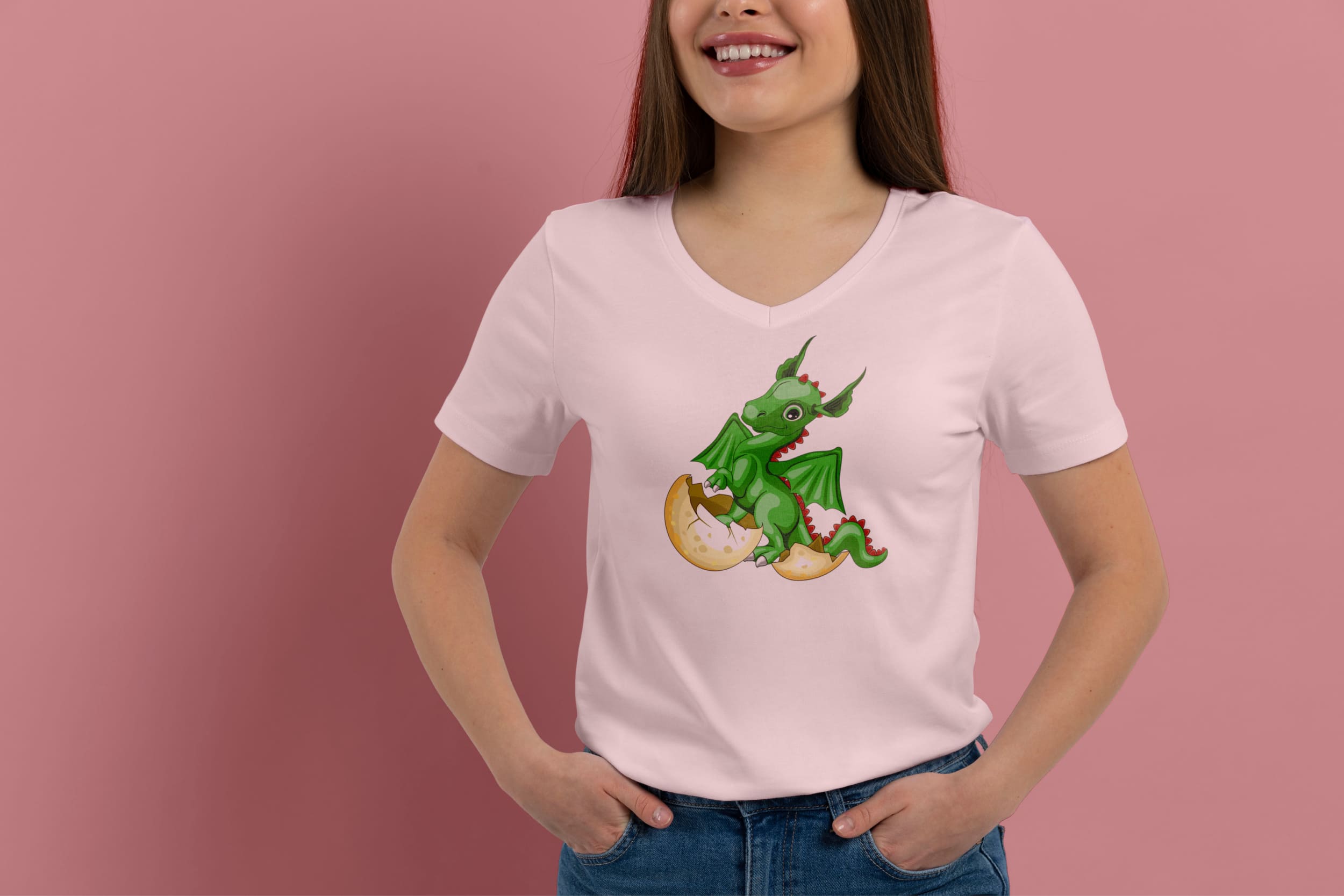 Light pink t-shirt on a girl with a green baby dragon hatched from an egg, on a pink background.