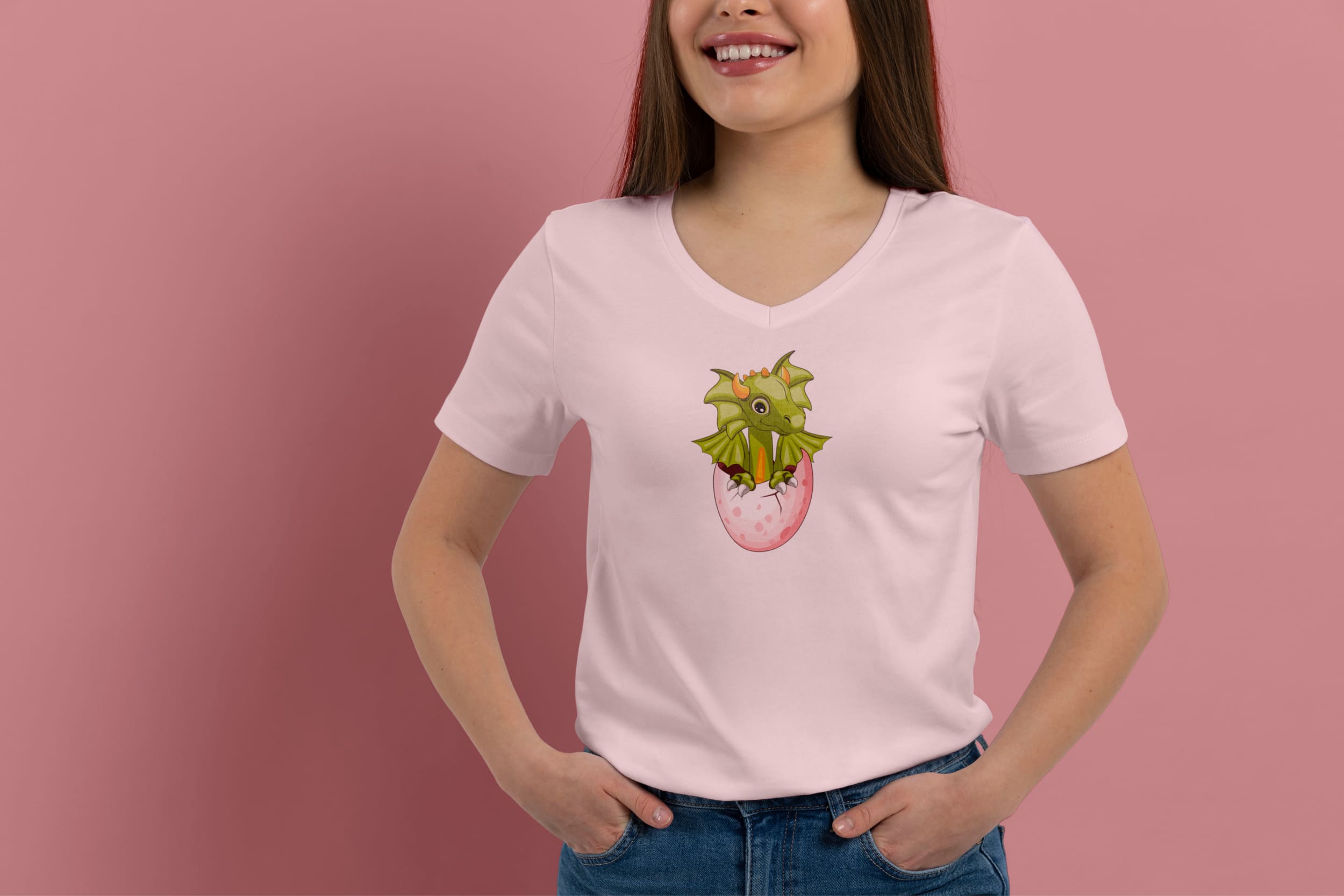 Light pink t-shirt on a girl with an olive baby dragon hatched from an egg, on a pink background.