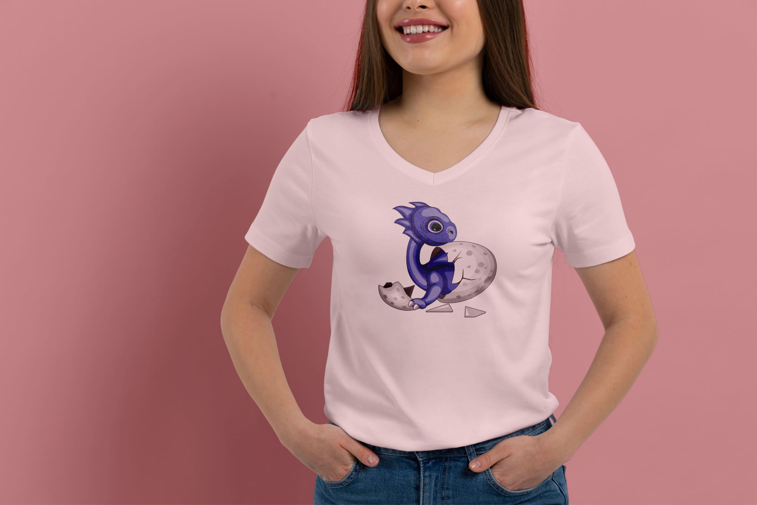 A light pink t-shirt on a girl with a blue dragon hatched from an egg, on a pink background.
