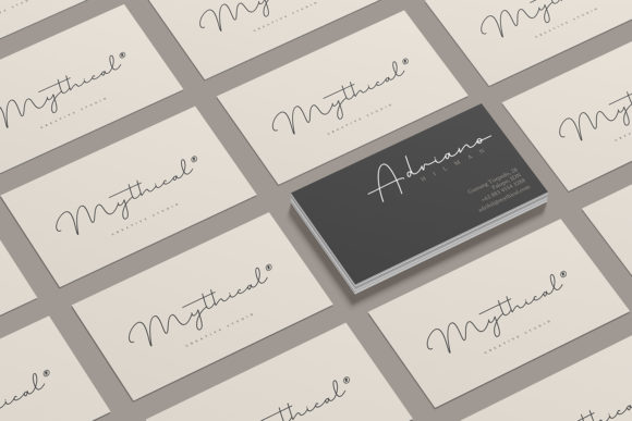 A set of white visiting cards with black lettering "Mythical" in script font and black cards with white lettering "Adriano" on a gray background.