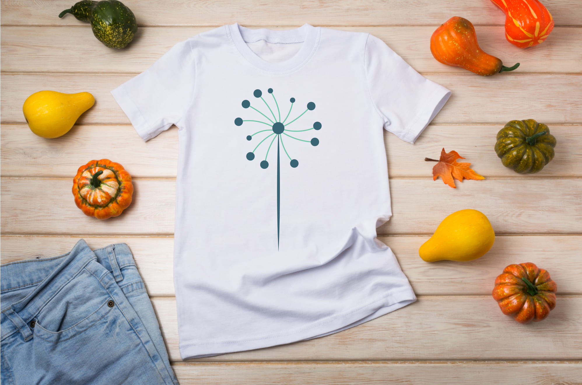 White T-shirt with a turquoise dandelion flower and pumpkins.