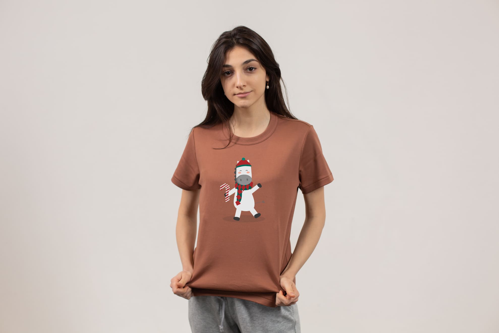 Brown t-shirt with a christmas horse on a girl on a gray background,