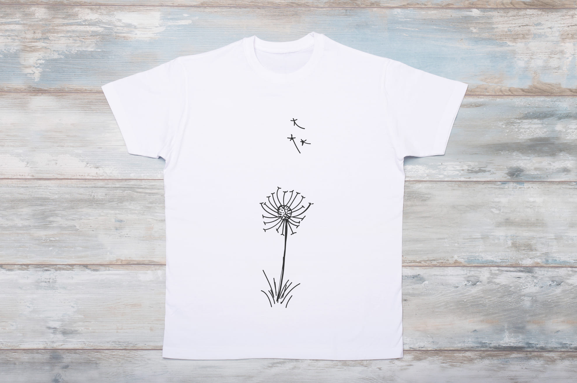 Image of white t-shirt with colorful dandelion print.