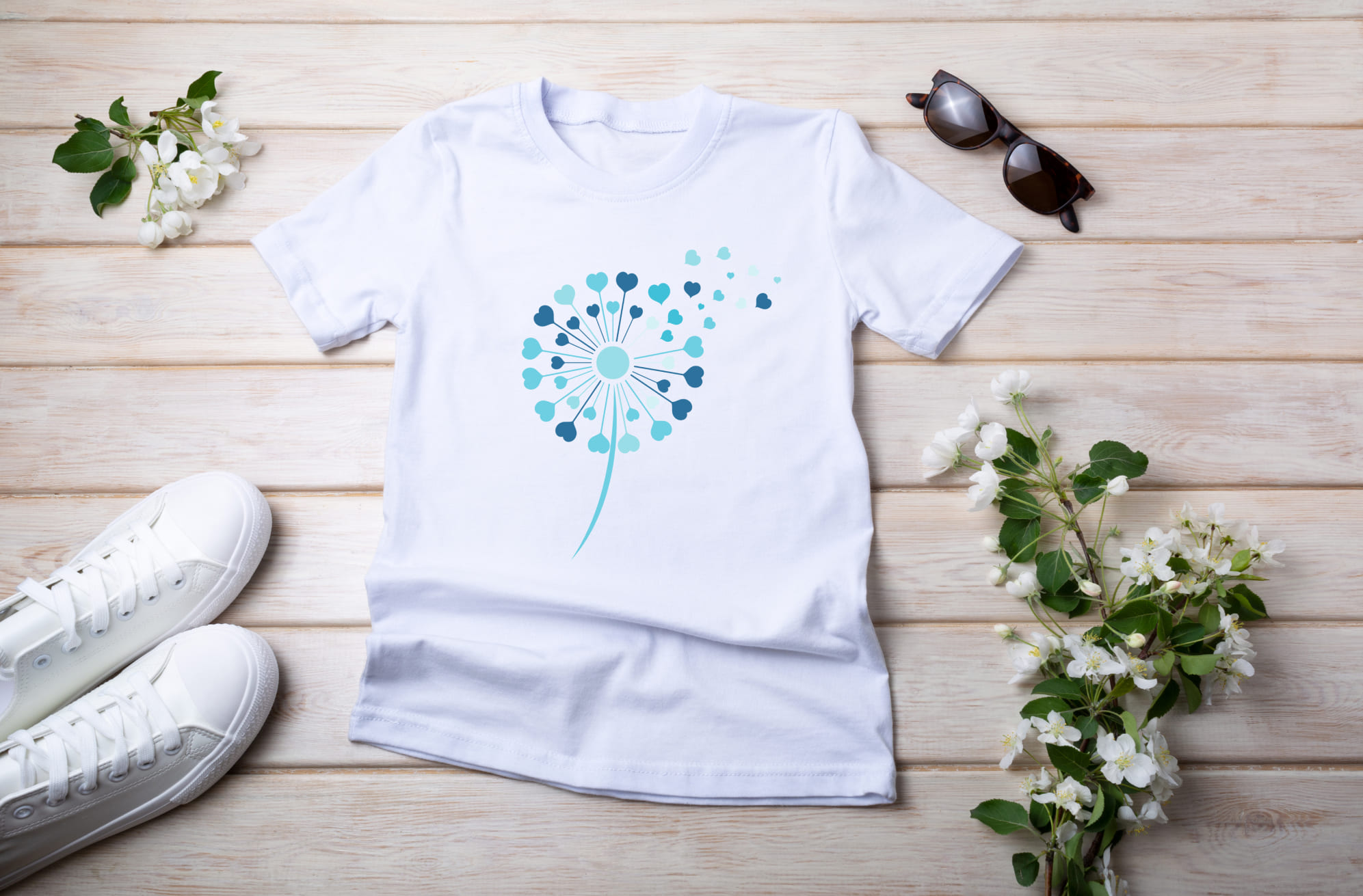 White T-shirt with light blue and blue dandelion flower and sunglasses with white sneakers.