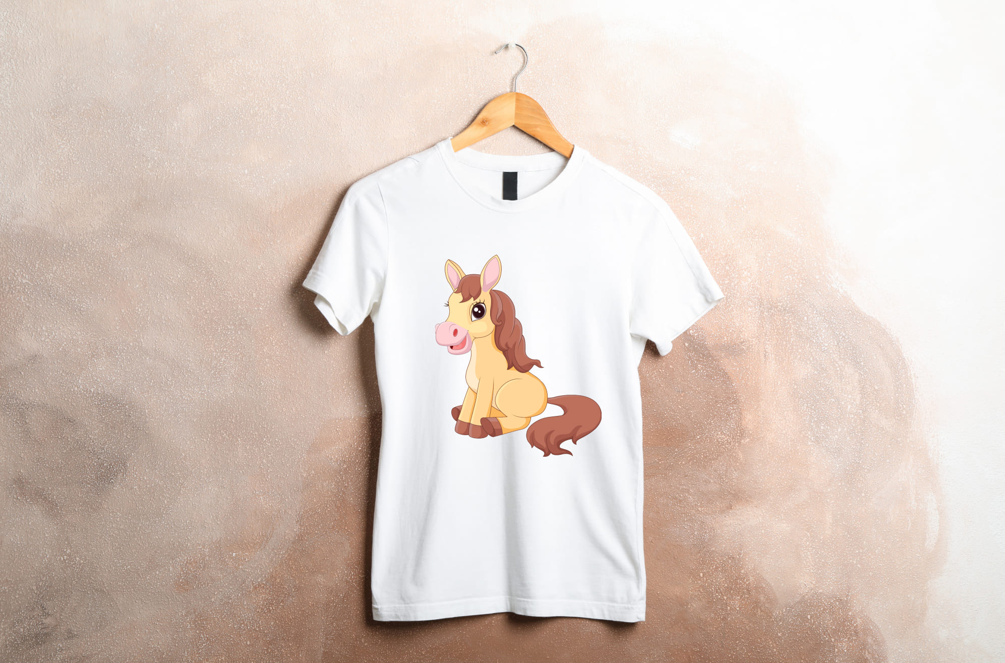 White t-shirt with a sitting horse on a wooden hanger on a beige background.
