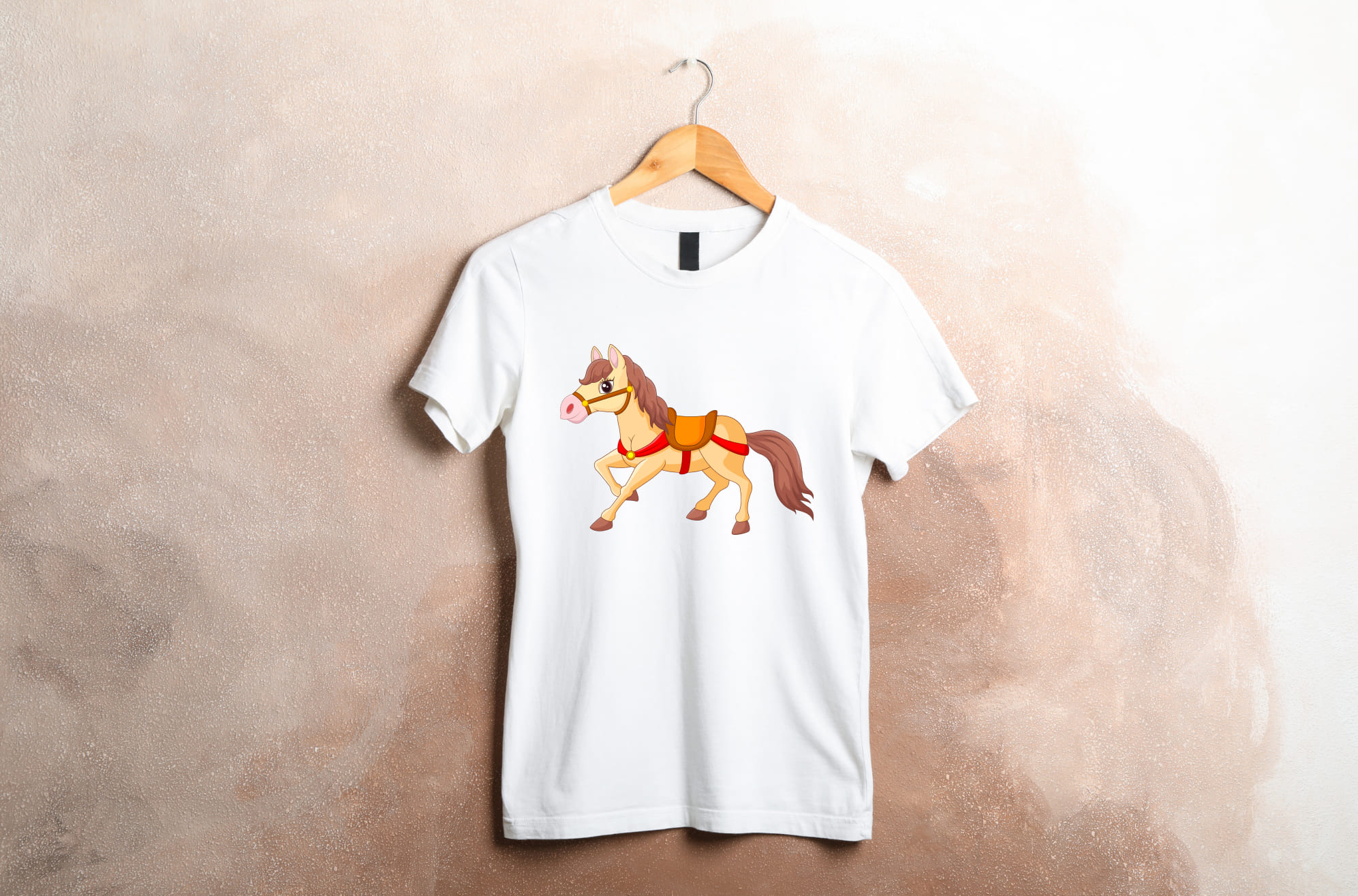 White t-shirt with a cute horse on a wooden hanger on a beige background.