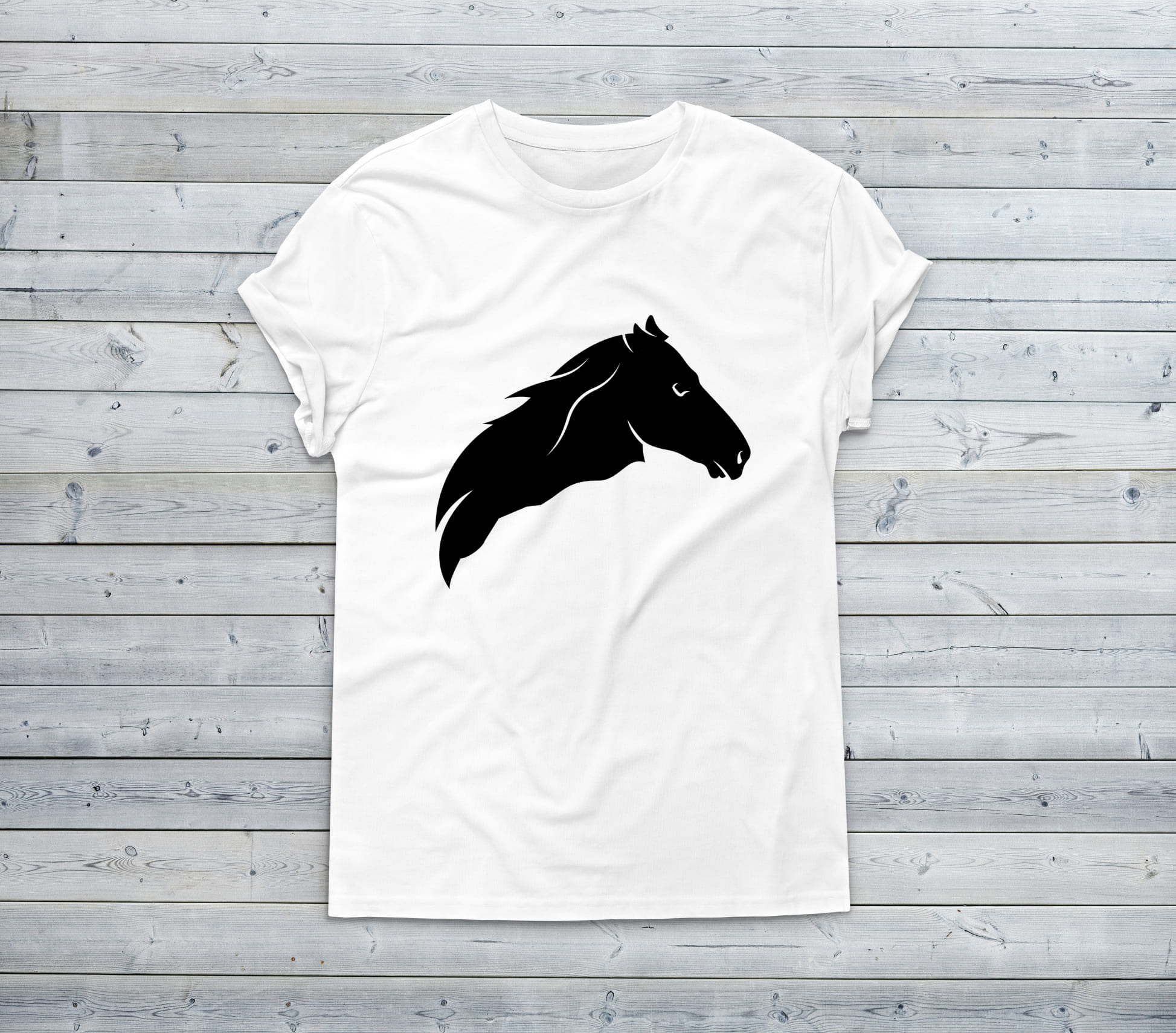 White t-shirt with a black horse head on a wooden background.