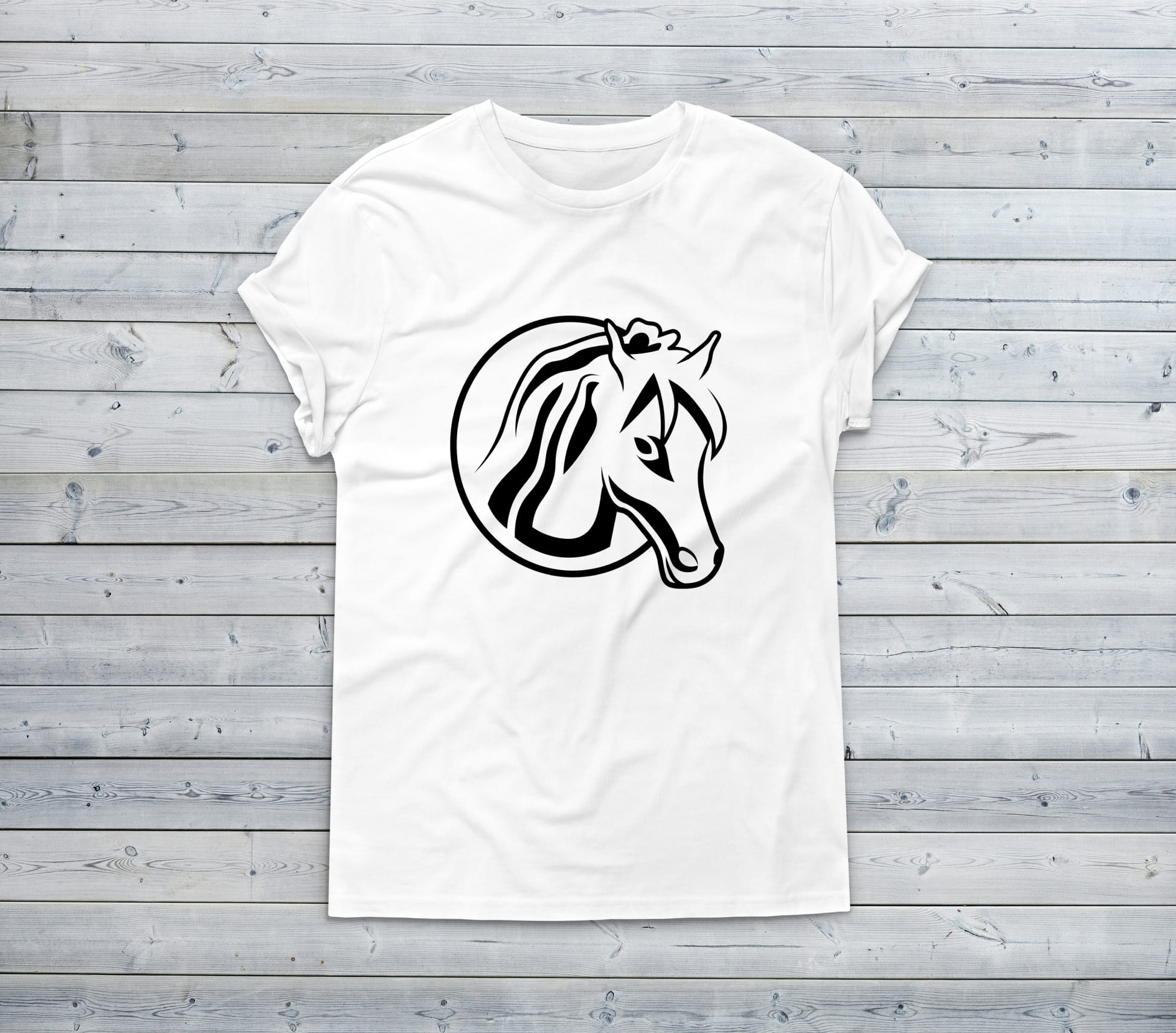White t-shirt with a black and white horse head on a wooden background.