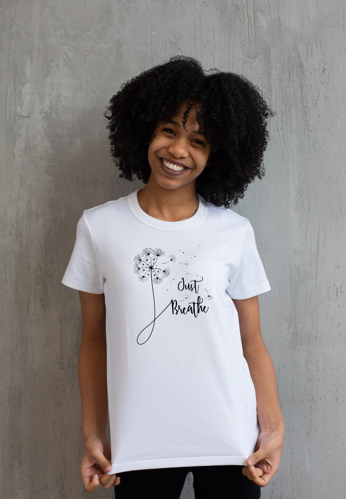 A white t-shirt with a just breathe dandelion on a girl.