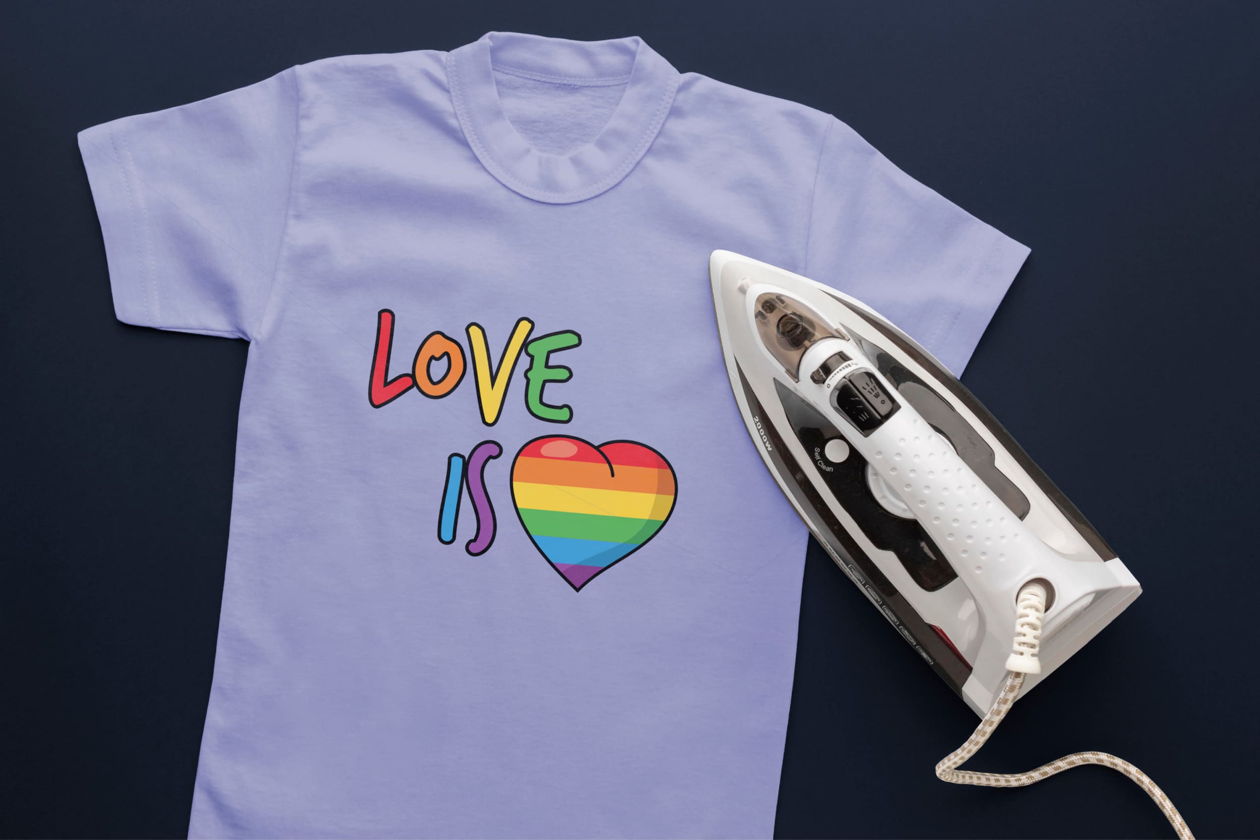 Light blue t-shirt with lettering "Love is" in LGBT colors and a heart in LGBT colors and an iron.