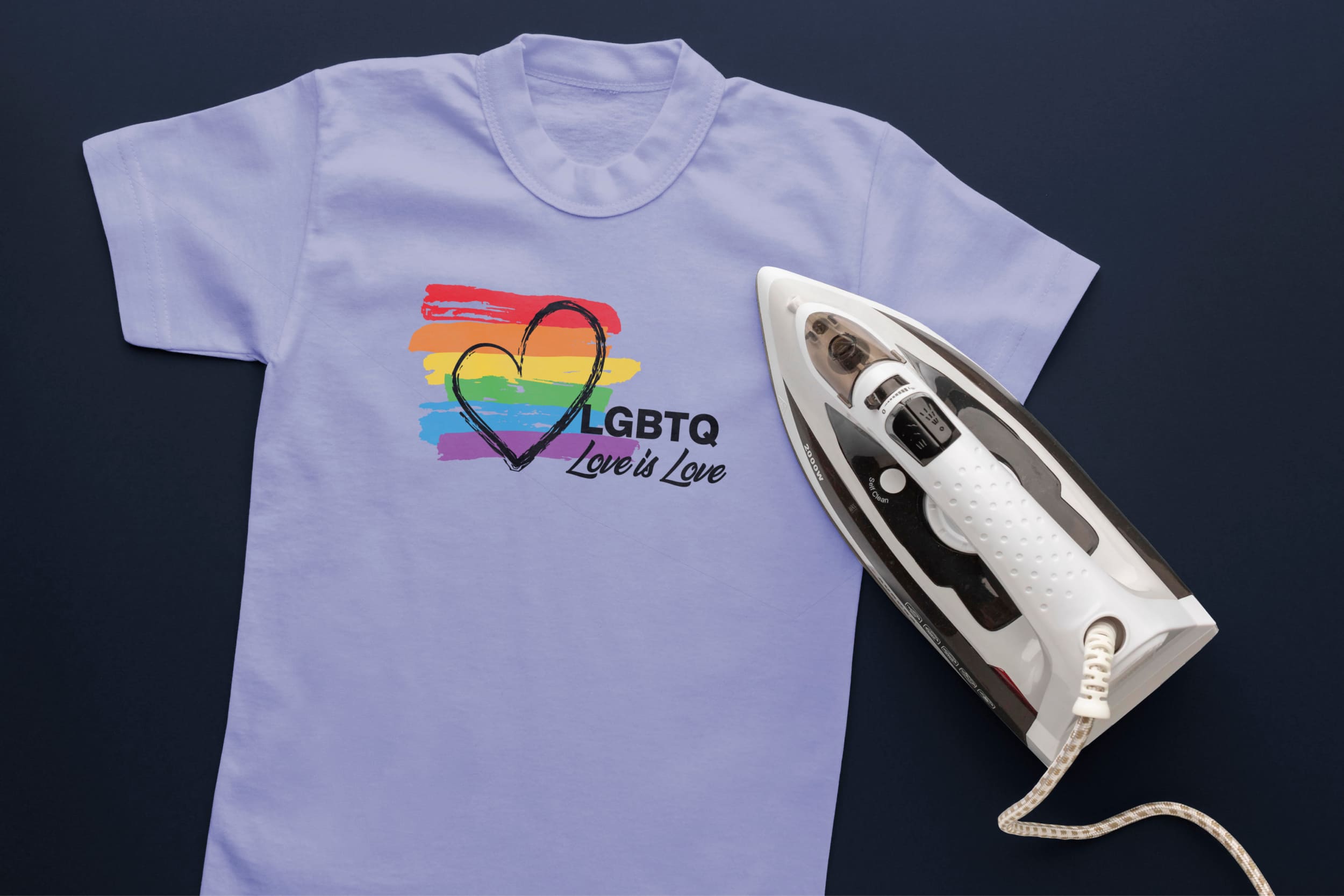 Light blue T-shirt with lines in LGBT colors, a black heart, black lettering "LGBTQ Love is Love" and an iron.