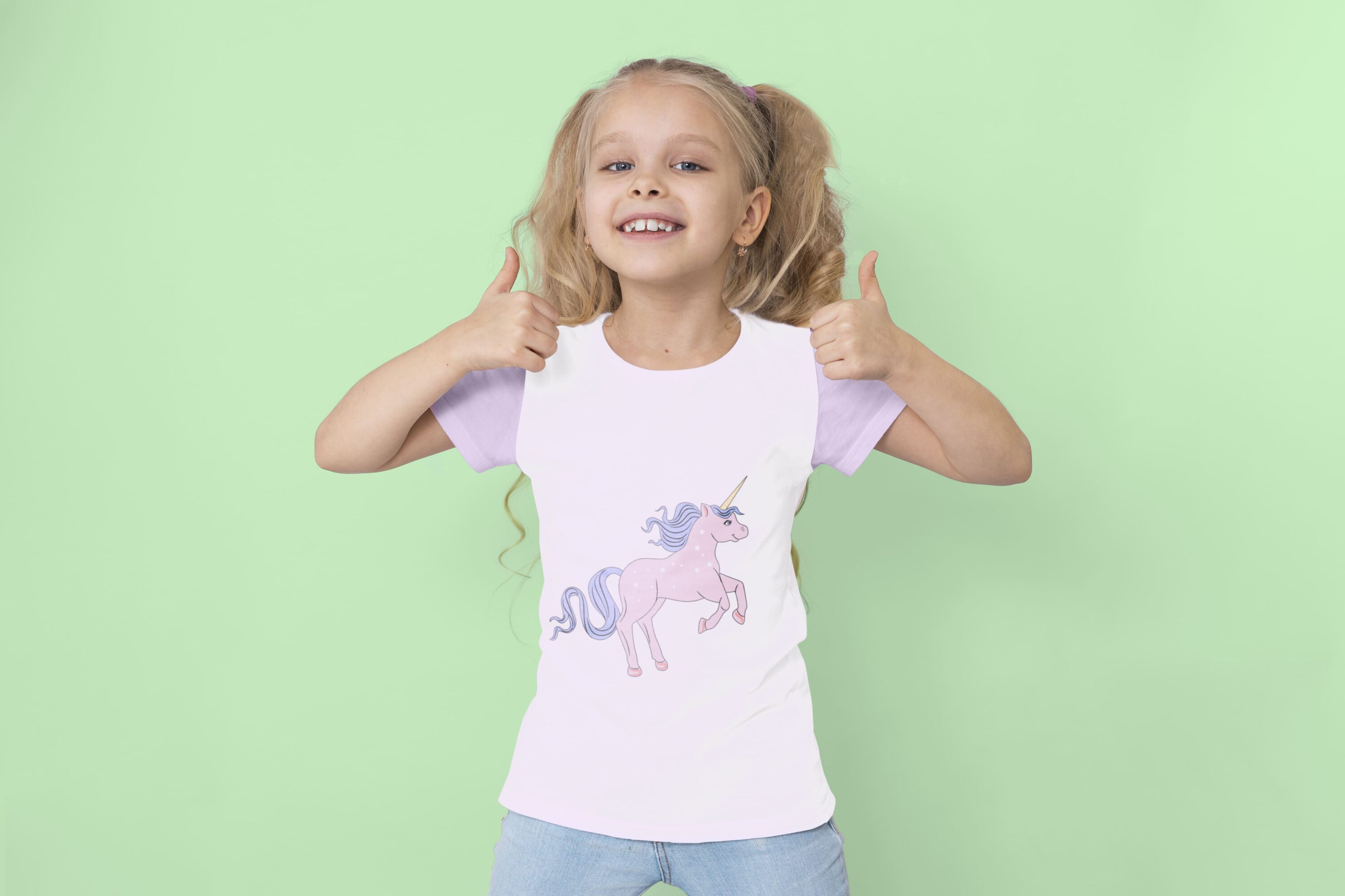 White t-shirt with lavender sleeves and a magical unicorn, on a girl on a mint background.