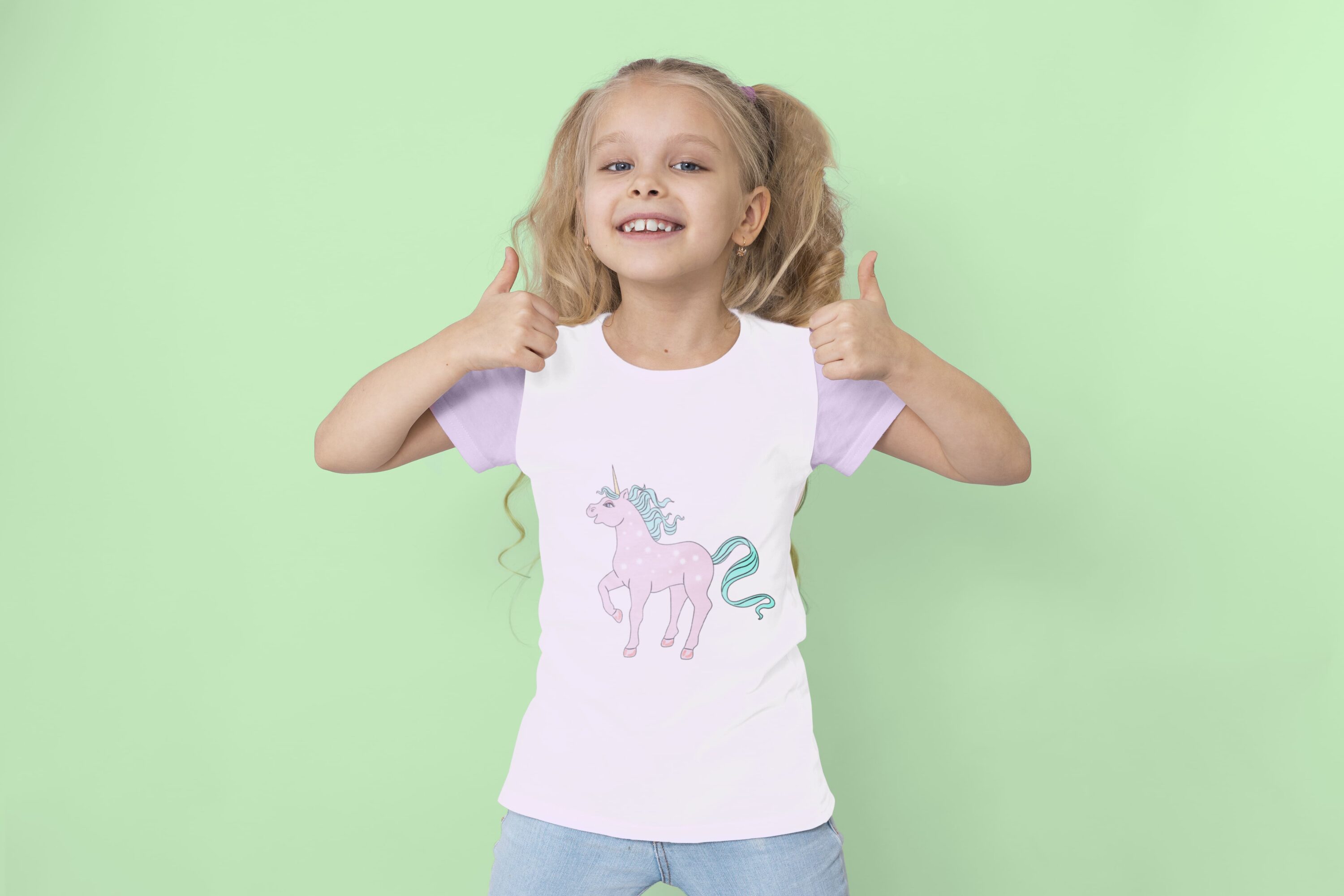 White t-shirt with lavender sleeves and a magical unicorn, on a girl on a mint background.